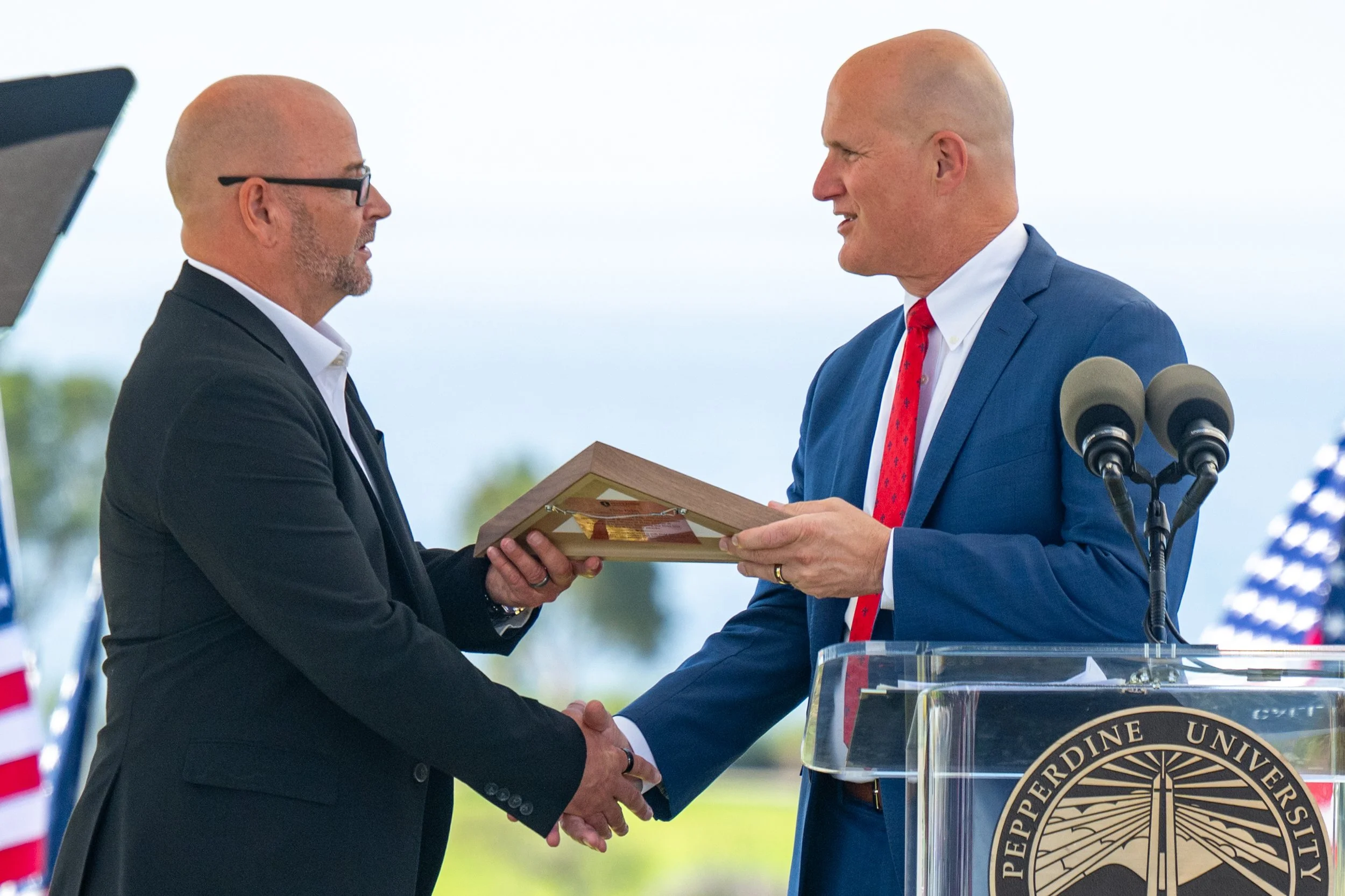  (R) Preident and Chief Excutive Officer Jim Gash gives honorary flag award to (L) Chris Fields at the Pepperdine University Waves of Flags 9/11 Rememberance Ceremony at Alumni Park on Friday, September 11, 2026, Malibu, Calif.  Fields worked the 199