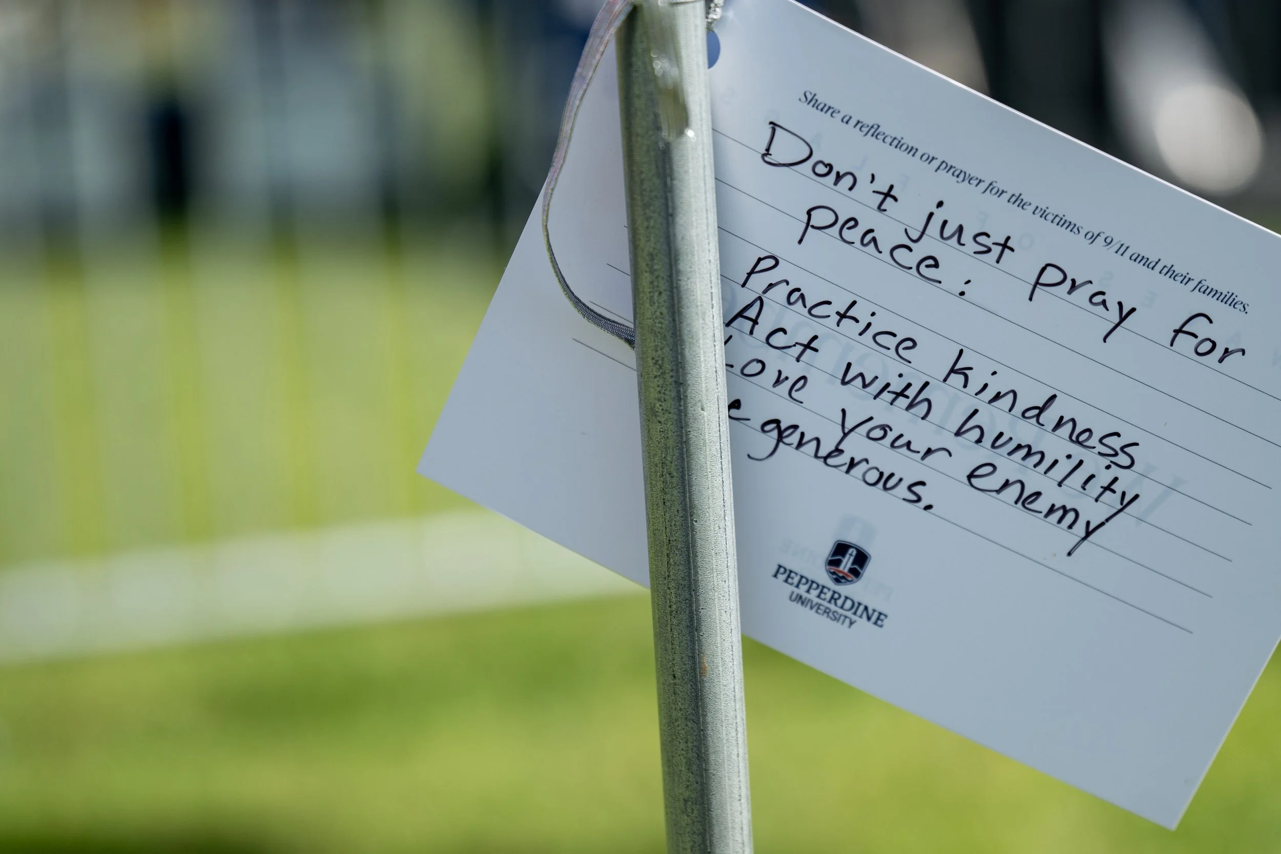  A prayer card ptied tot he pull of an American flag at the Waves of Flags at the Pepperdine University  9/11 Rememberance Ceremony Alumni Park on Friday, September 11, 2026, Malibu, Calif. People had the opportuniy to place a prayer card on flag, th