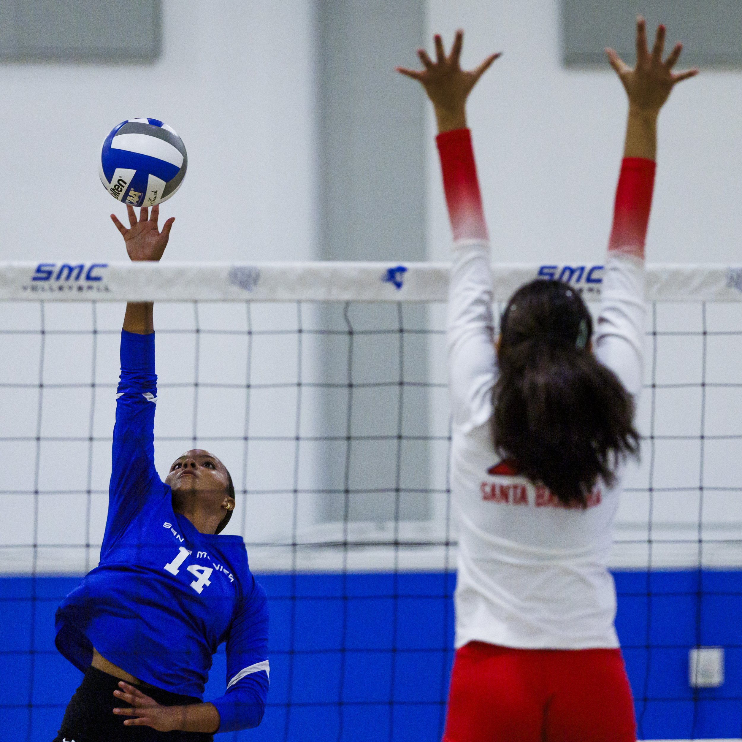  Santa Monica College (SMC) Corsair Quinci Wilder (14) (Left) spikes the ball as Santa Barbara City College Vaquero Makeleta Leilani Stepp (20) (Right) tries to block it during their game on Wednesday, September 23, 2026, at the SMC Corsair Gym in Sa
