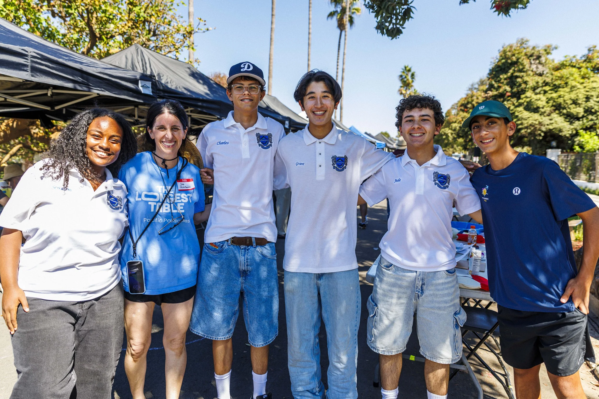  Pacific Palisades High School Ambassadors pose for a photograph during the second annual Longest Table Potluck Picnic Sunday, Oct. 4, 2026, on Pampas Ricas Blvd. in Pacific Palisades, Calif. The students volunteered to help set up and break down the