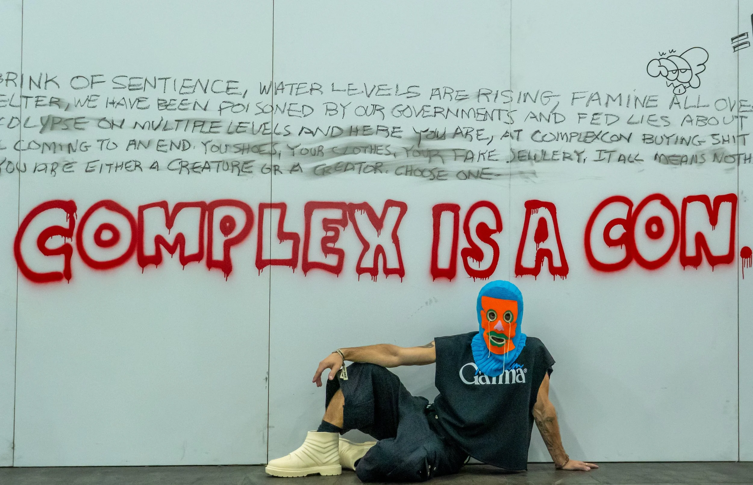  Gamma Gabe posing at ComplexCon across his booth under art that condemns Consumerism at ComplexCon in the Los Angeles Convention Center on Sunday October 4th, 2026. (Andy Garcia | The Corsair) 