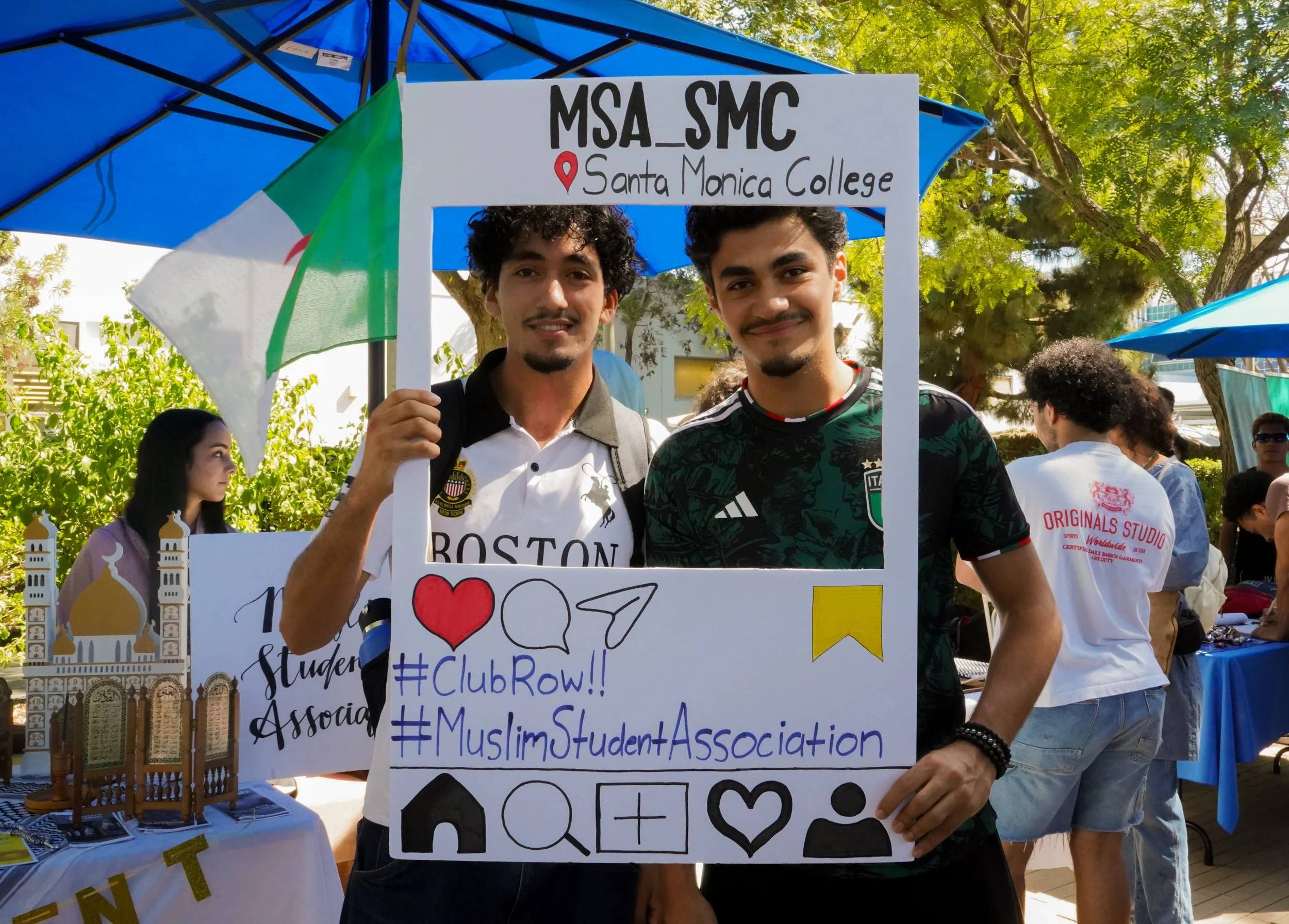  Middle Eastern and North African Club president and business major Mehei Hidouche (left) poses inside a custom photo frame booth alongside a fellow student during a club awareness event at Santa Monica college on Friday, June 5,  2026. The 20 member