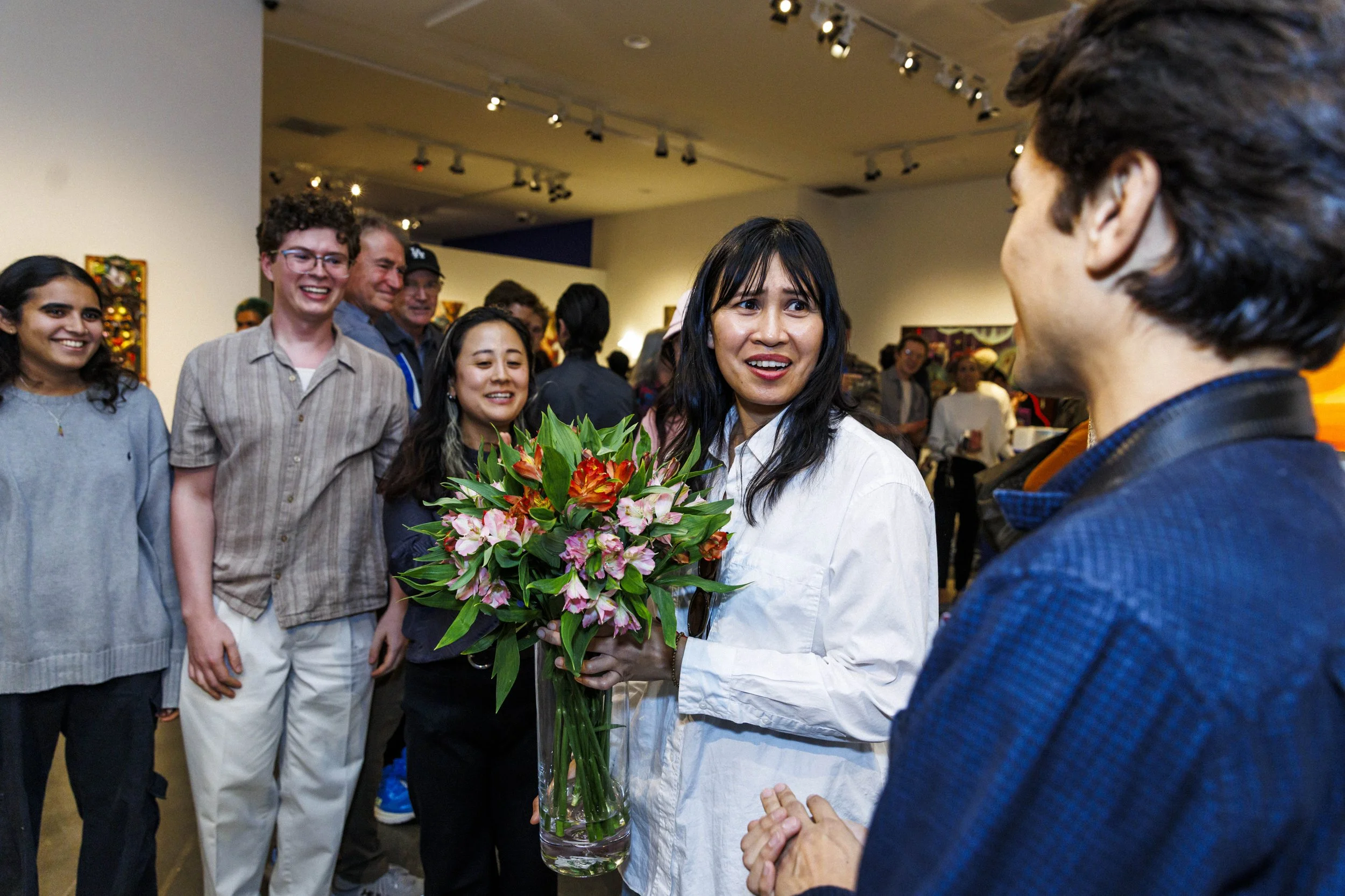  Santa Monica College (SMC) art professor Kim Garcia (center) receives flowers from her students during the opening reception for the SMC Art Department "Living Echoes" exhibit on Tuesday, Oct. 13, 2026, at the Pete and Susan Barrett Gallery in Santa
