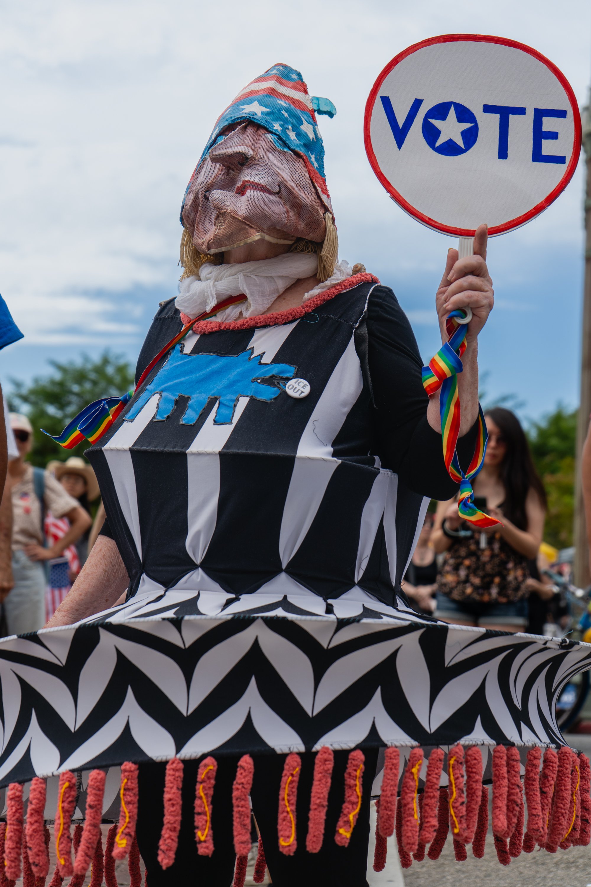  Protestor, Jennifer Robertson, wearing her handmade mask and costume, holding a 'vote' sign in front of Los Angeles City Hall on Saturday, Oct. 17, 2026. (Steve Lopez | The Corsair) 