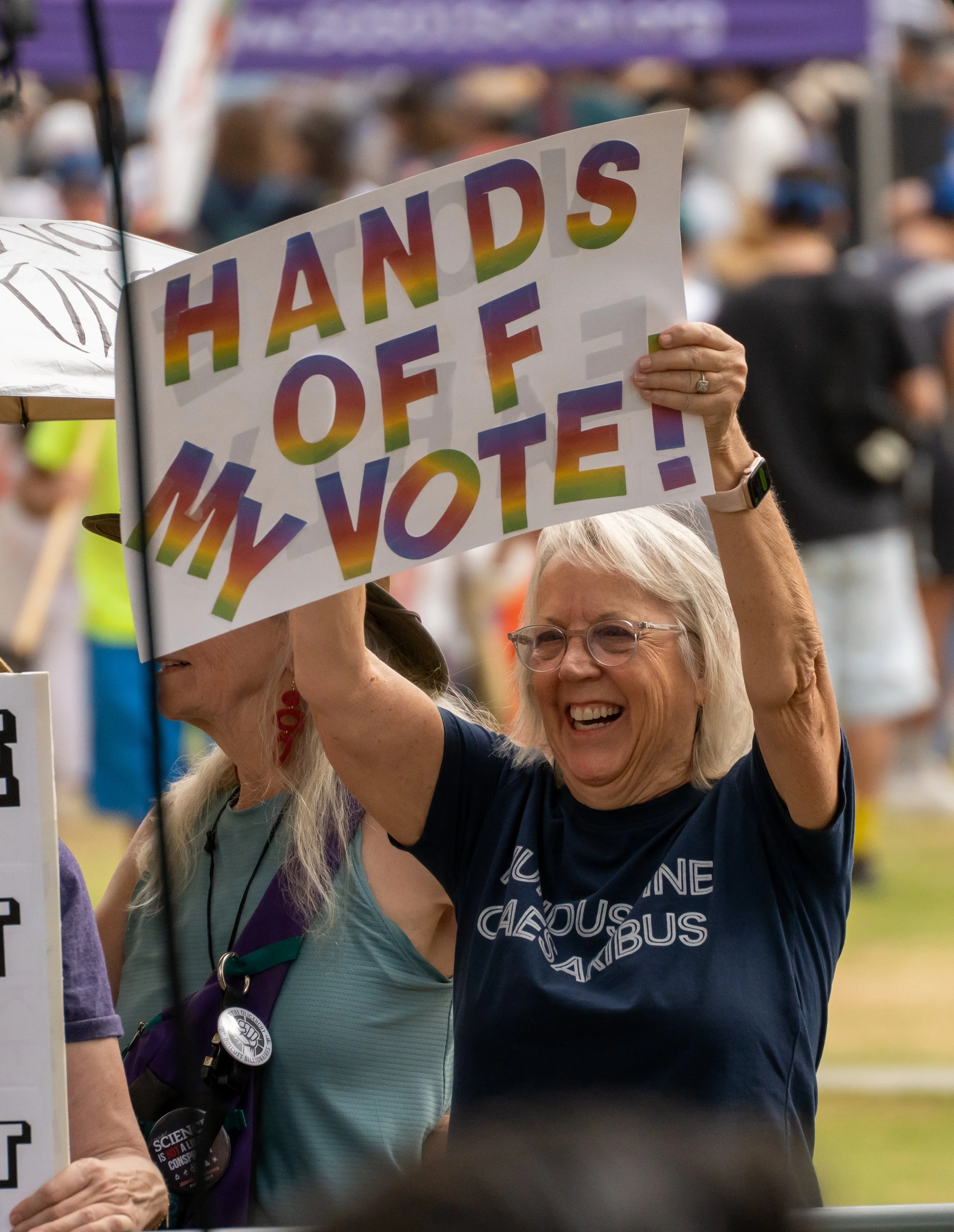  A protester holding a rainbow-lettered sign reading "Hands Off My Vote!" during a rally outside Los Angeles City Hall near Grand Park in downtown Los Angeles, Calif. Saturday, Oct. 17. (Jose Hernandez | The Corsair) 
