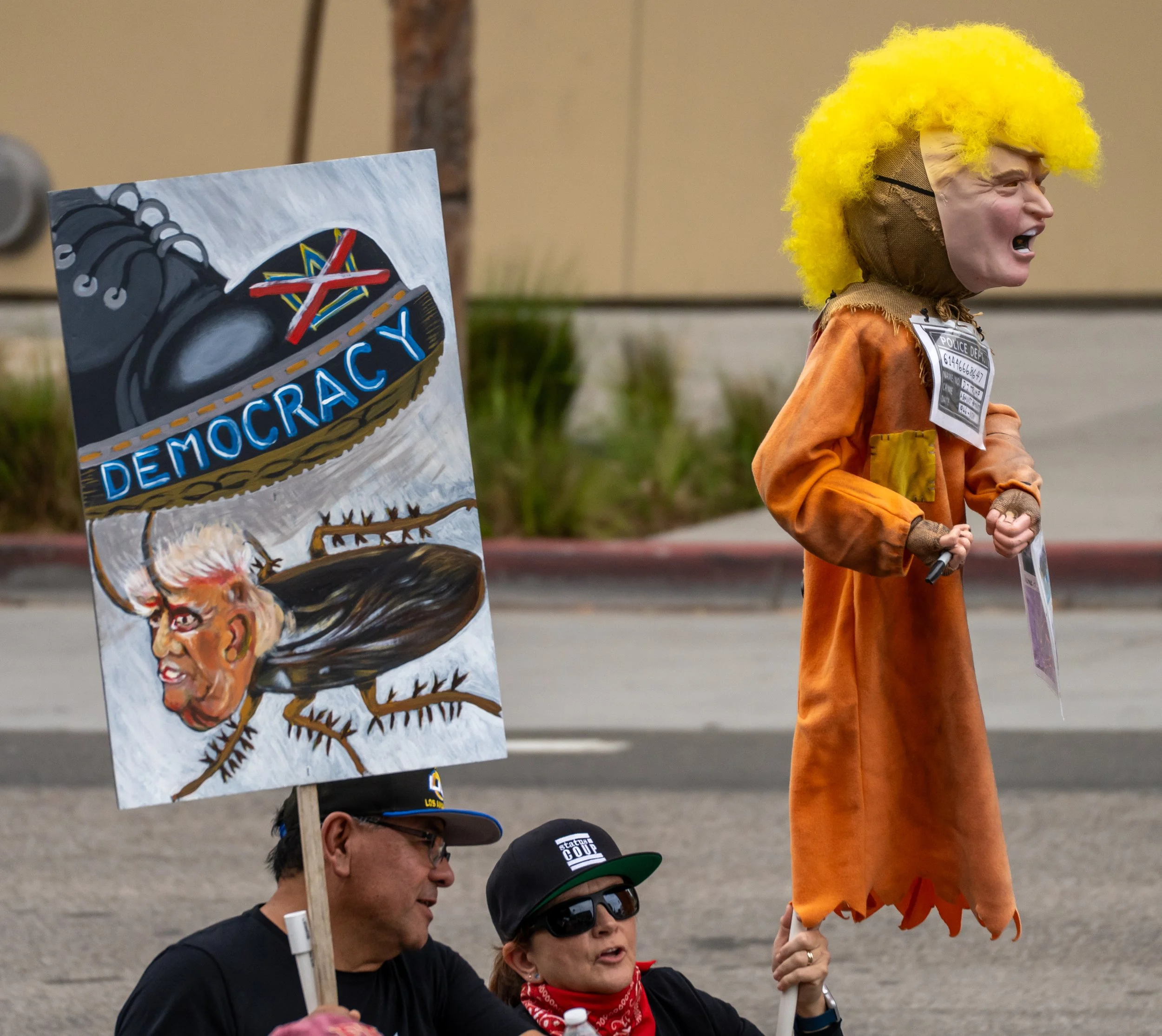  A Protester marching while art showing "Boot squishing trump as a cockroach" & Doll of Donald Trump at Grand Street, downtown Los Angeles, Calif. Saturday, Oct. 17. (Jose Hernandez | The Corsair) 