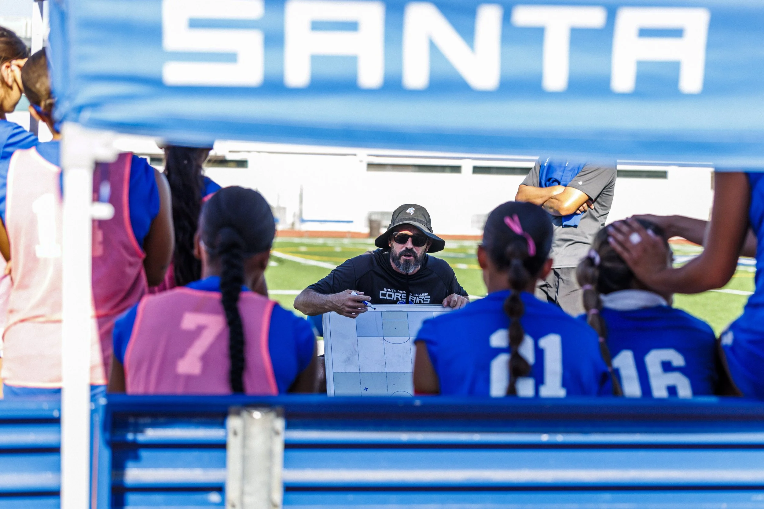  Santa Monica College (SMC) Corsair coach Aaron Benditson (center)  gives his players instructions at halftime during their match against College of the Canyons Cougars on Friday, Oct. 16, 2026, at the SMC Corsair Stadium in Santa Monica, Calif. Temp