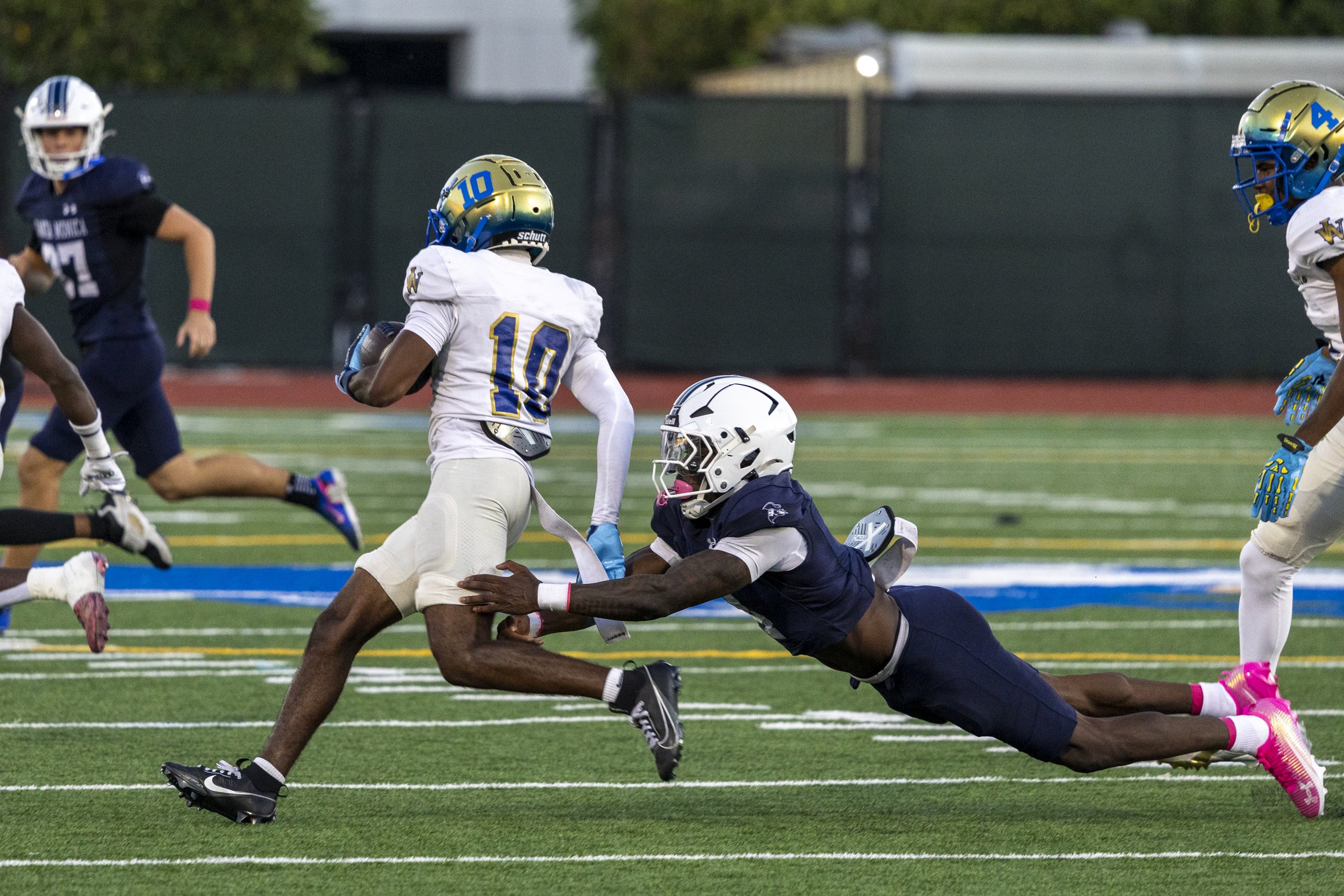  Santa Monica College (SMC) Defensive Back (DB) Marc Toupuissant (4) goes for the tackle of West Los Angeles College Wildcat DB Corey Hudson (10) in the second quarter of the Corsairs’ Homecoming game at Corsair Field in Santa Monica, Calif., on Satu
