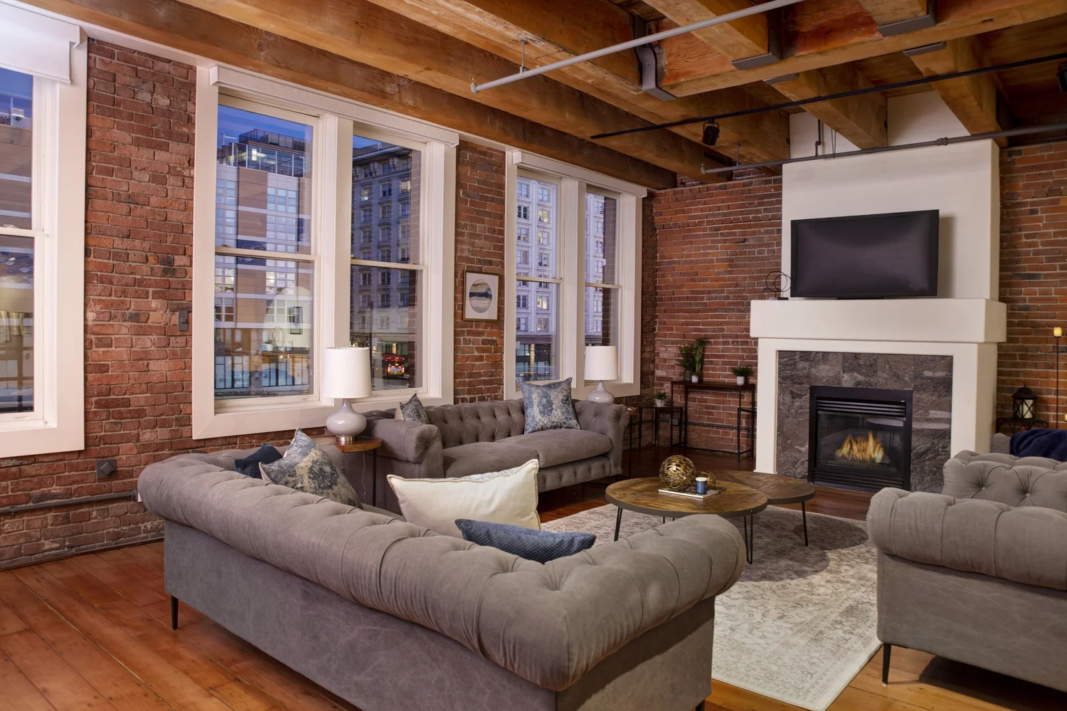 Brick-walled loft living room at dusk, prepared and photographed for a Brian Huie listing