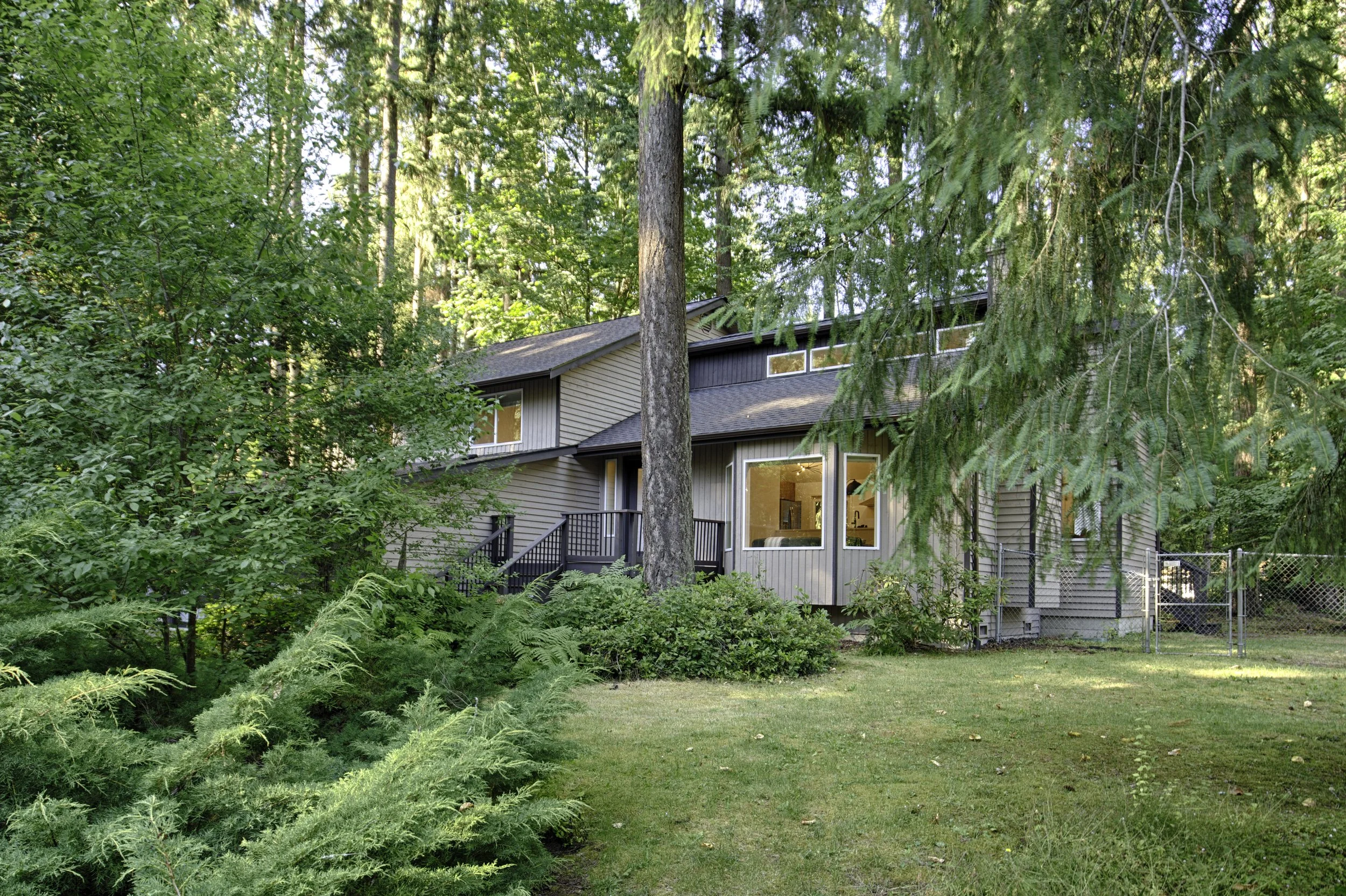 Lush front yard with mature greenery for privacy