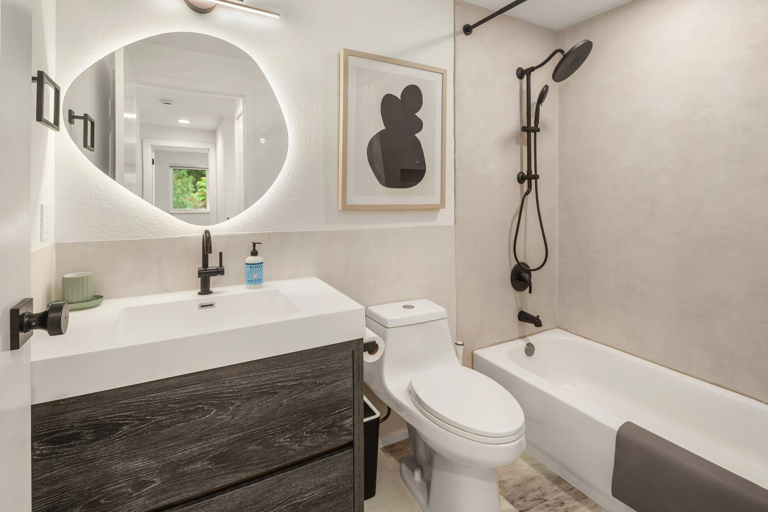 Hallway bathroom with backlit mirror