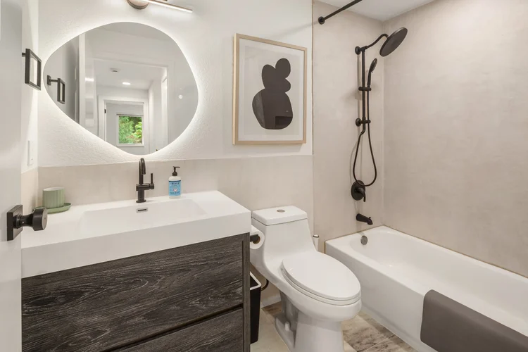 Hallway bathroom with backlit mirror