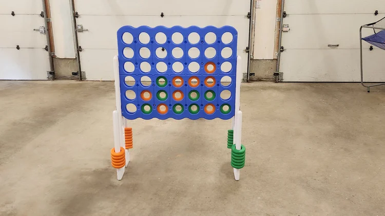 Giant four-in-a-row game with orange and green discs in the garage