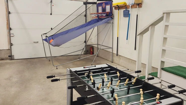 Garage game area with foosball table and an arcade basketball hoop