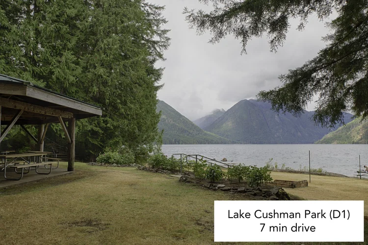 Picnic shelter on a lawn beside Lake Cushman with mountains beyond, Park D1
