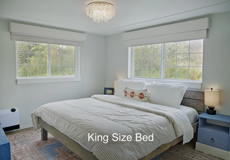 Bedroom with king size bed, two windows with valances and blue nightstands, King Size Bed caption