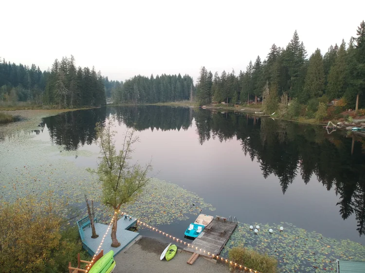 Aerial view down the Graham lake from the beach, dock and paddle boat at twilight