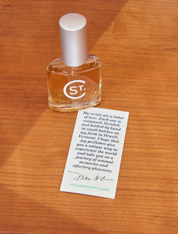 St. Clair Scents perfume bottle on desk with note card