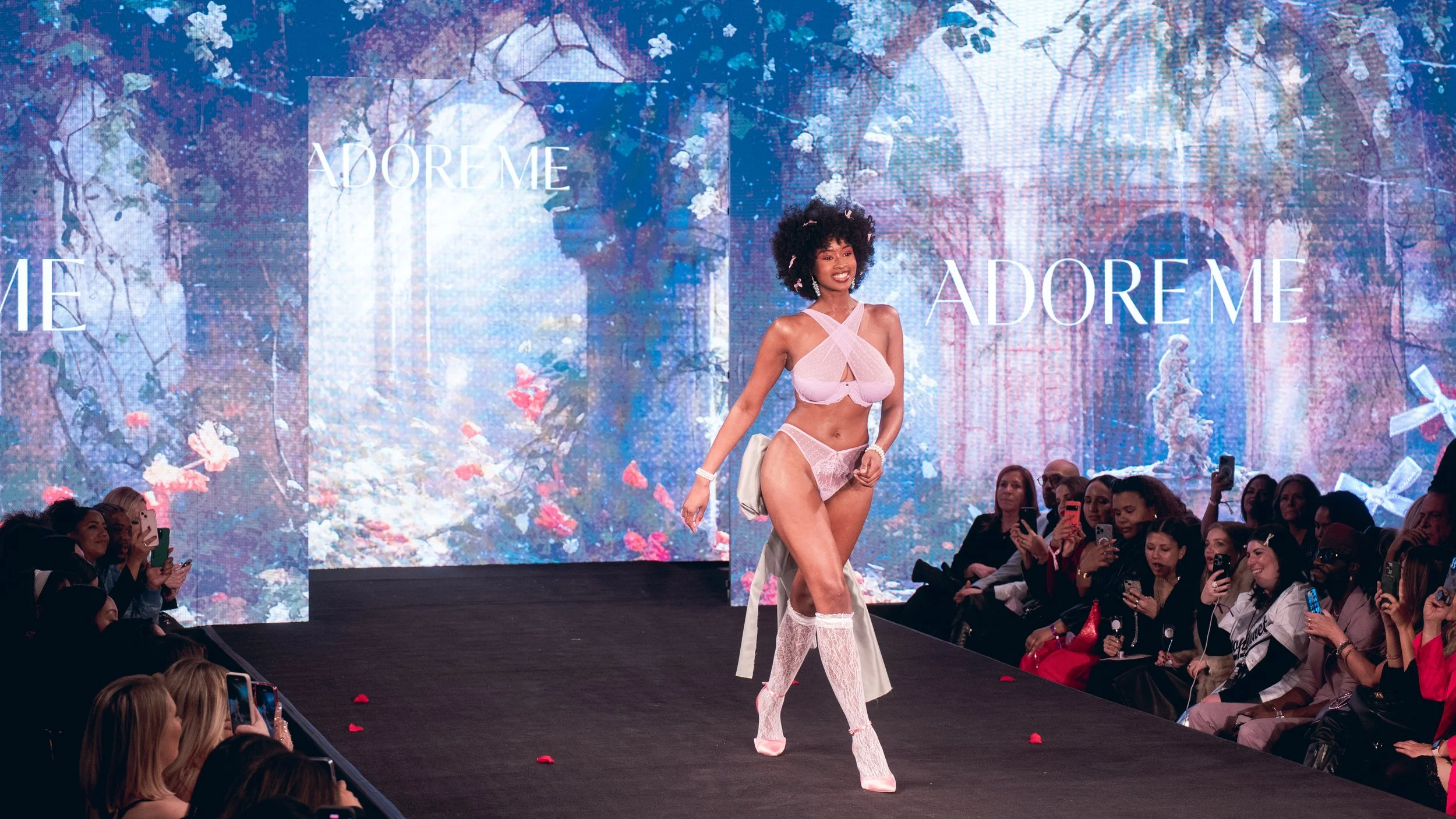Model in white and pink lingerie walks the Adore Me runway in white boots at New York Fashion Week 2024
