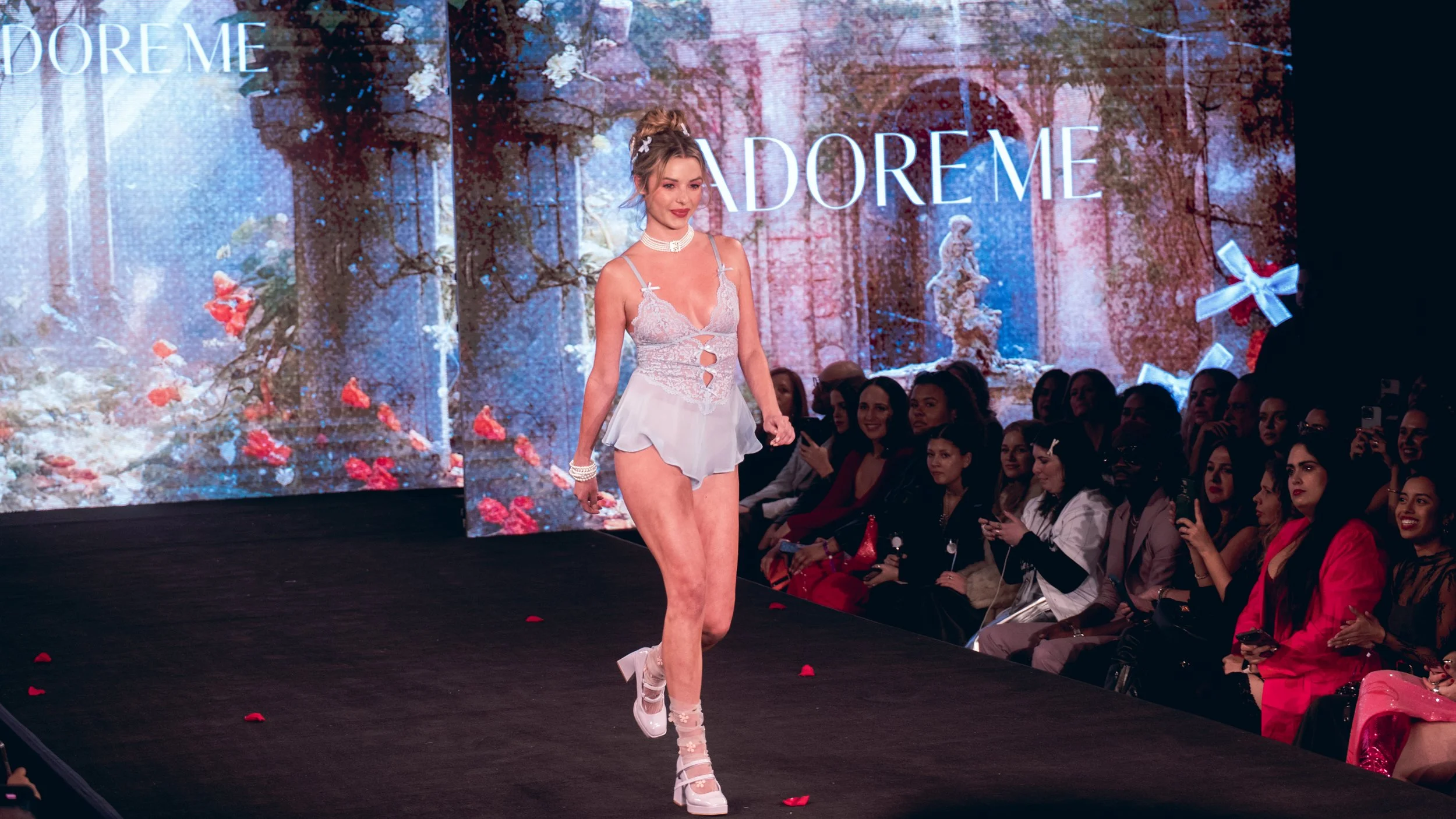 Model in a pale runway outfit walks past the audience on the Adore Me runway at New York Fashion Week 2024