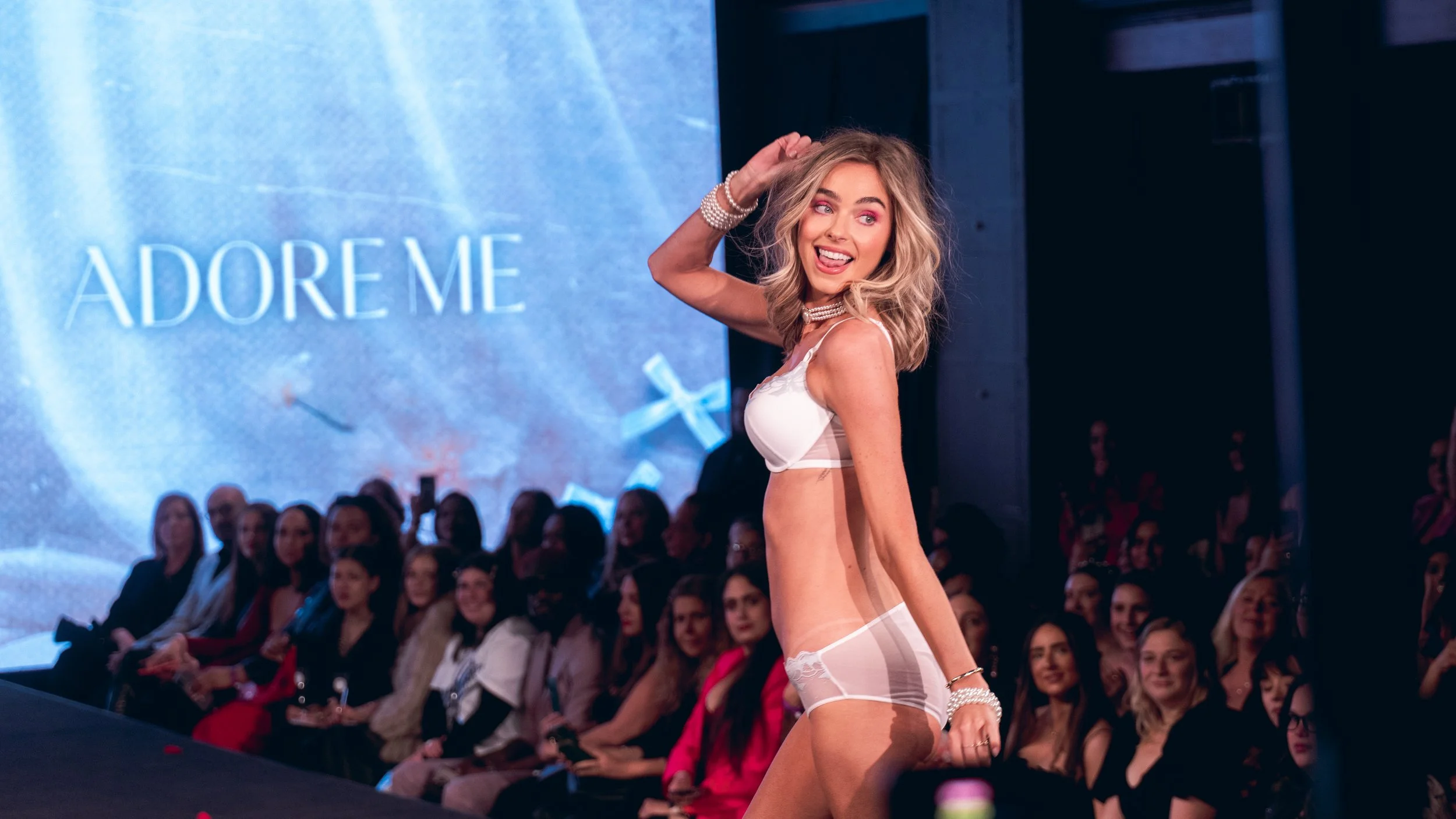 Blonde model in white lingerie poses on the Adore Me runway at New York Fashion Week 2024