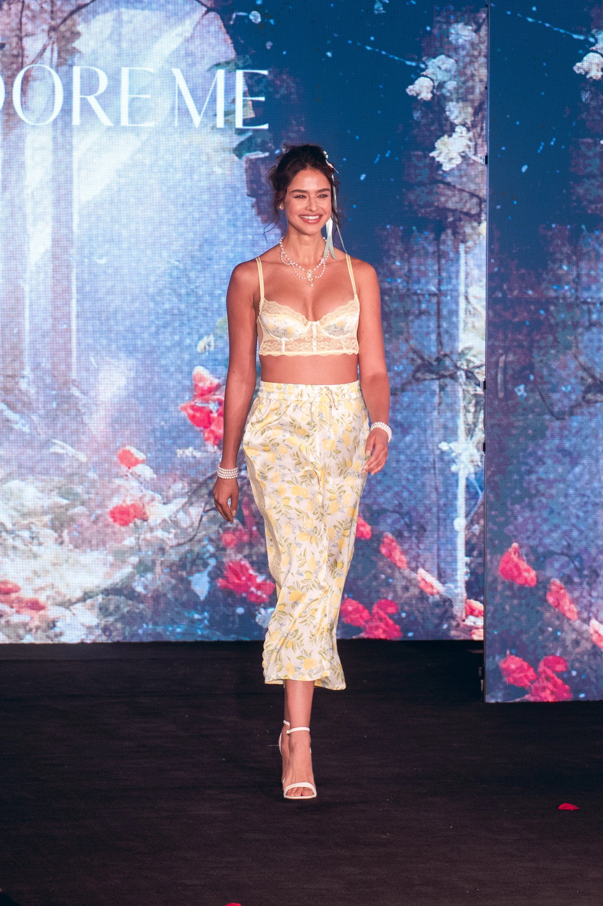 Model in a yellow floral crop top and pants walks the Adore Me runway at New York Fashion Week 2024