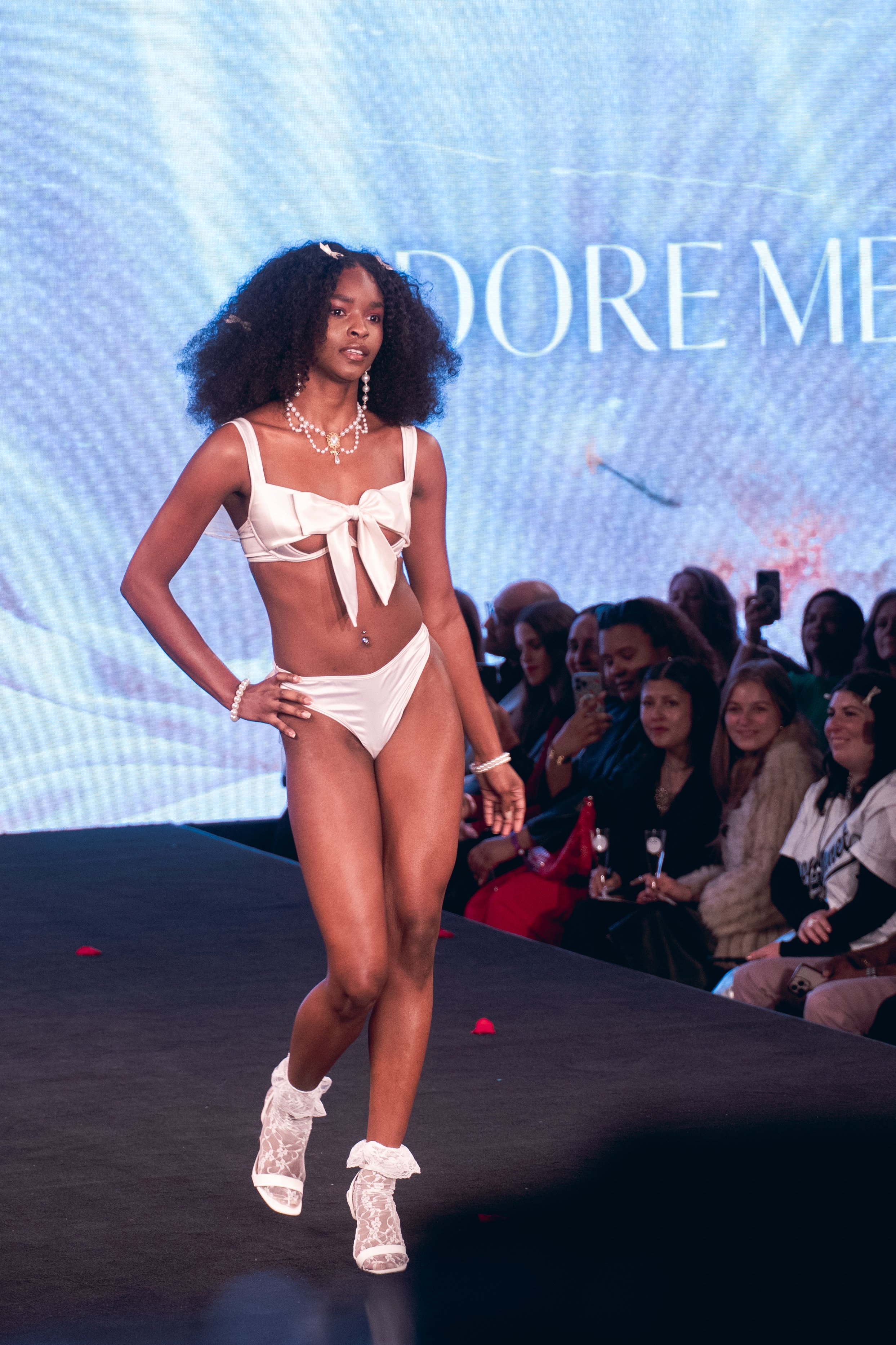 Model in white lingerie strides down the Adore Me runway at New York Fashion Week 2024