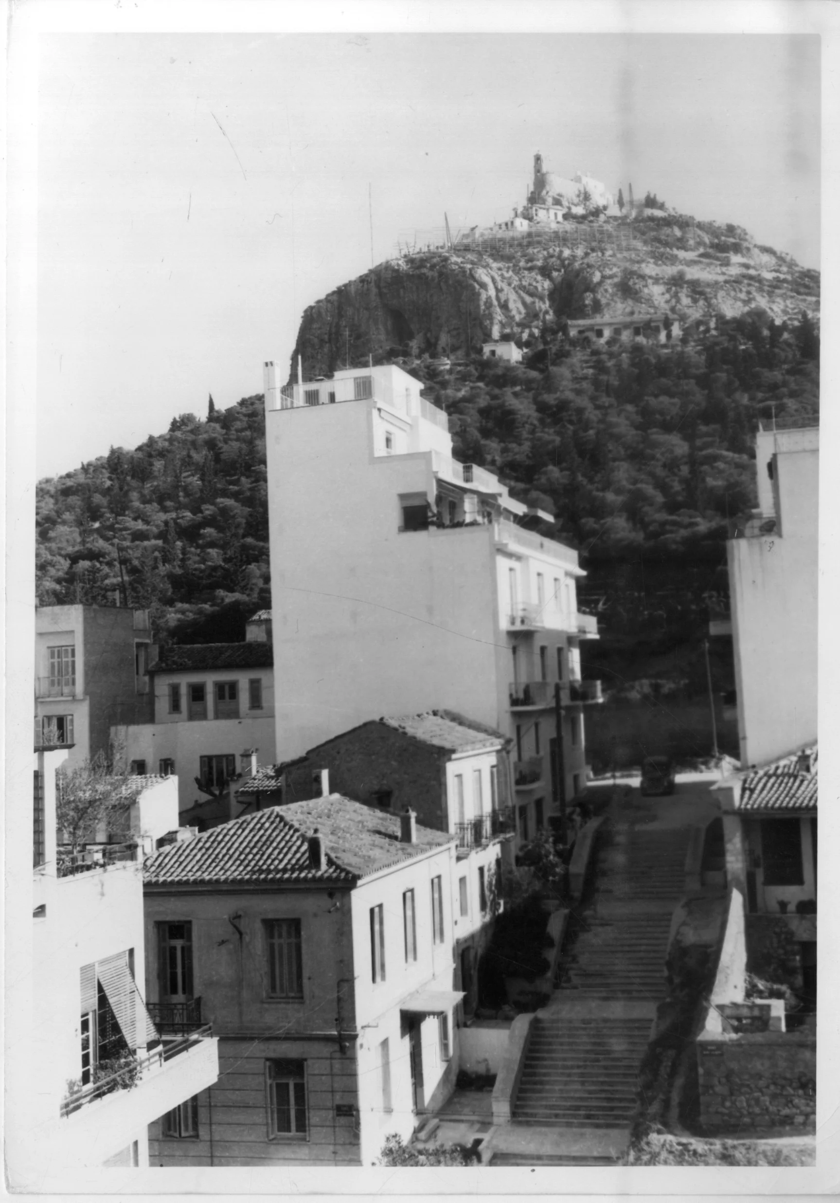 A view of Lycabettus Hill, ca 1950. Below, a typical street in the upper-middle class area of Kolonaki with neoclassical and early nineteenth-century domestic buildings, just starting to be developed with new polykatoikía . © Benaki Museum, Costas.