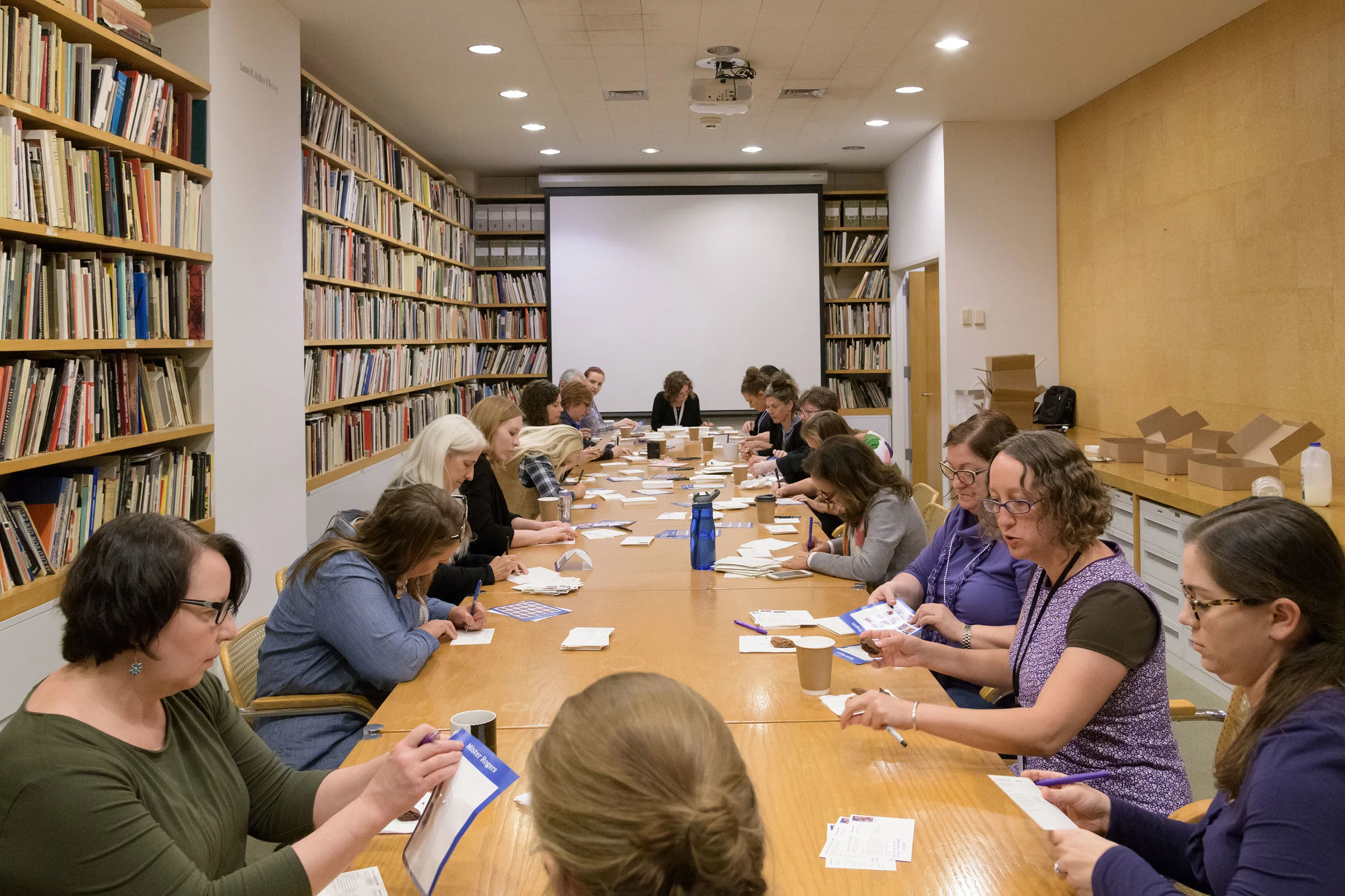 Carnegie Museum of Art staff writing 2,018 postcards inviting households across Pittsburgh to the 57th Carnegie International . © Carnegie Museum of Art, Pittsburgh. Photo: Bryan Conley.
