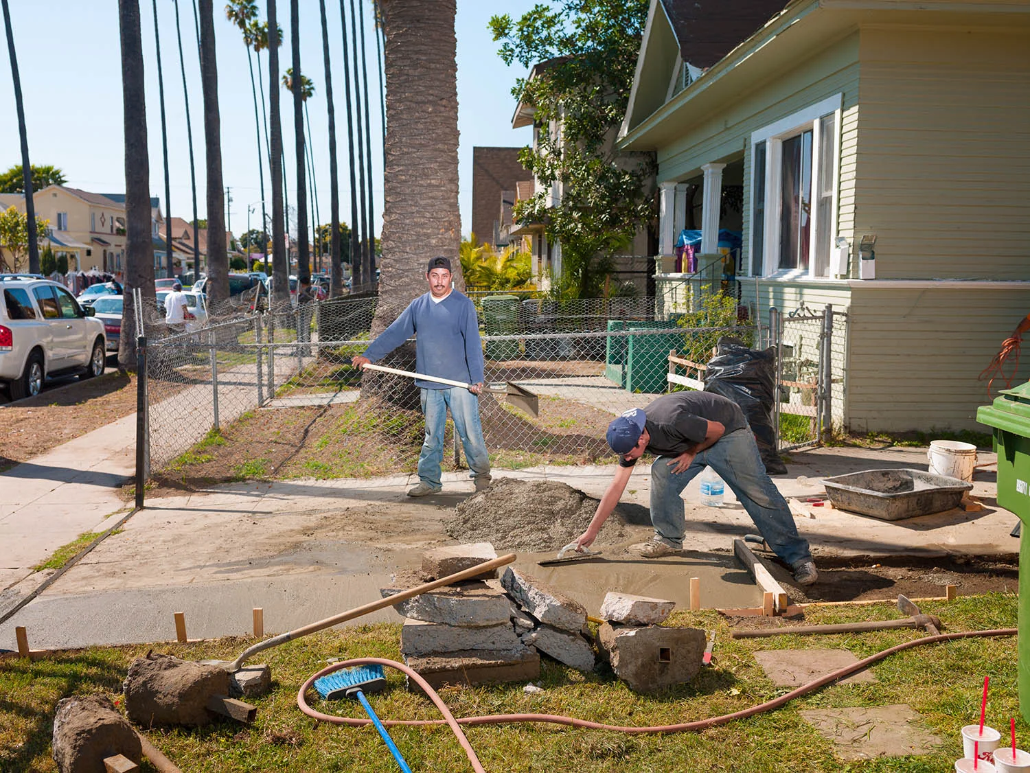 Valentin Romero mixes fresh concrete while Juan Hernandez trowels it into place on E. 43rd St. on March 3, 2012.