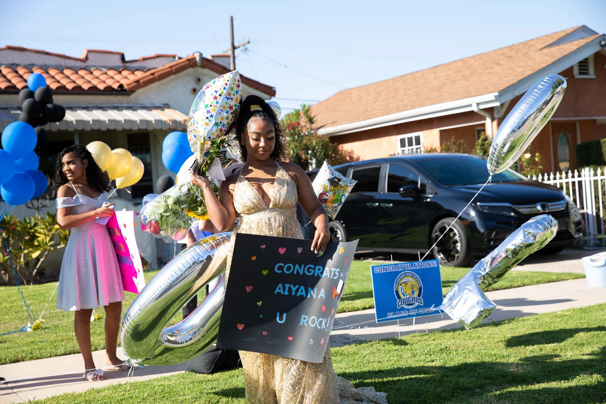  Carloads of family and friends wave, whistle and shower Aiyana Lopez-Spears with love, gifts and balloons in a drive-by party to celebrate her graduation from Crenshaw High School. "The quarantine [allowed] me to get myself together mentally, physic