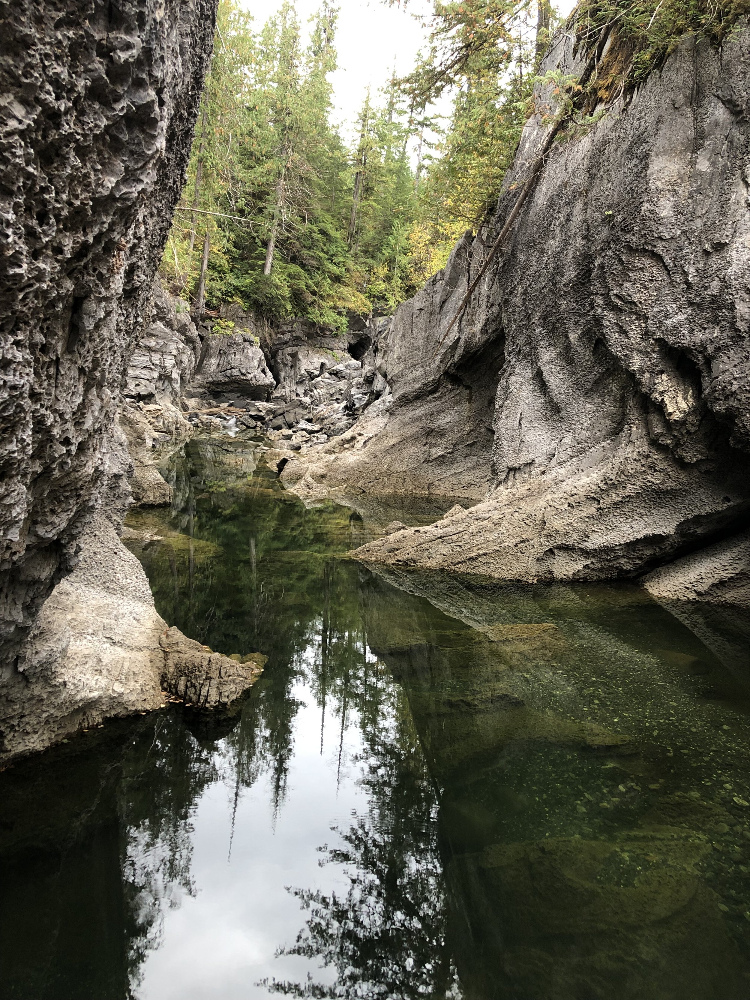 Rock formations and reflections in the water at San Josef Bay