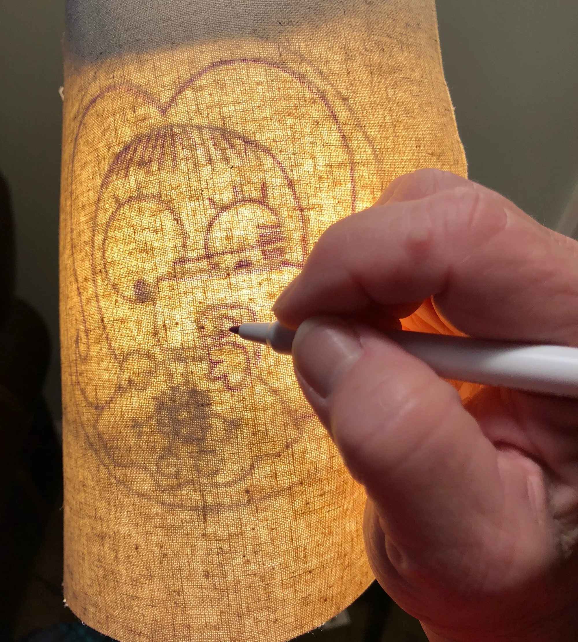 You can either use a sunny window or hold it on a lamp shade as I did here. Use a disappearing pen to trace the drawing.