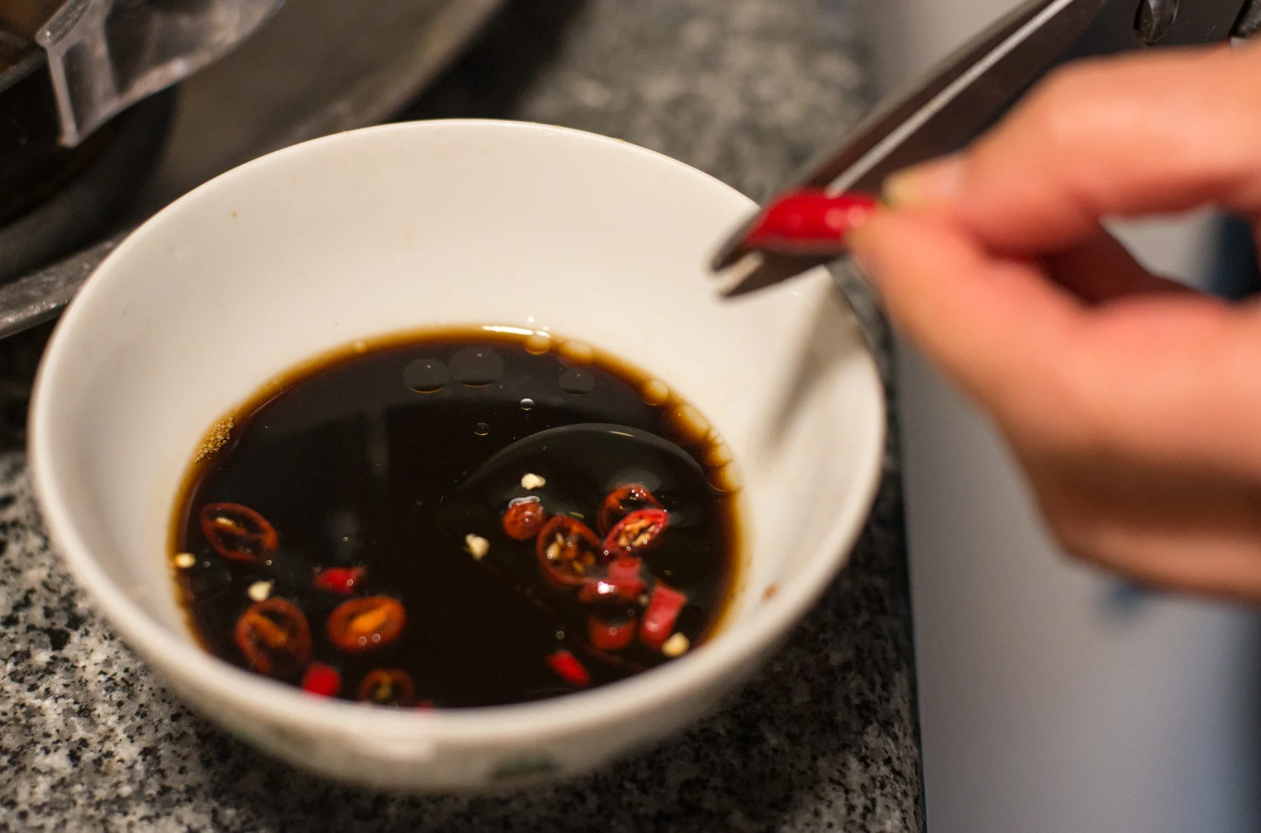 Prepare a dipping sauce while you're waiting for the dumplings to cook. This is vinegar, sesame oil and chilli. 
