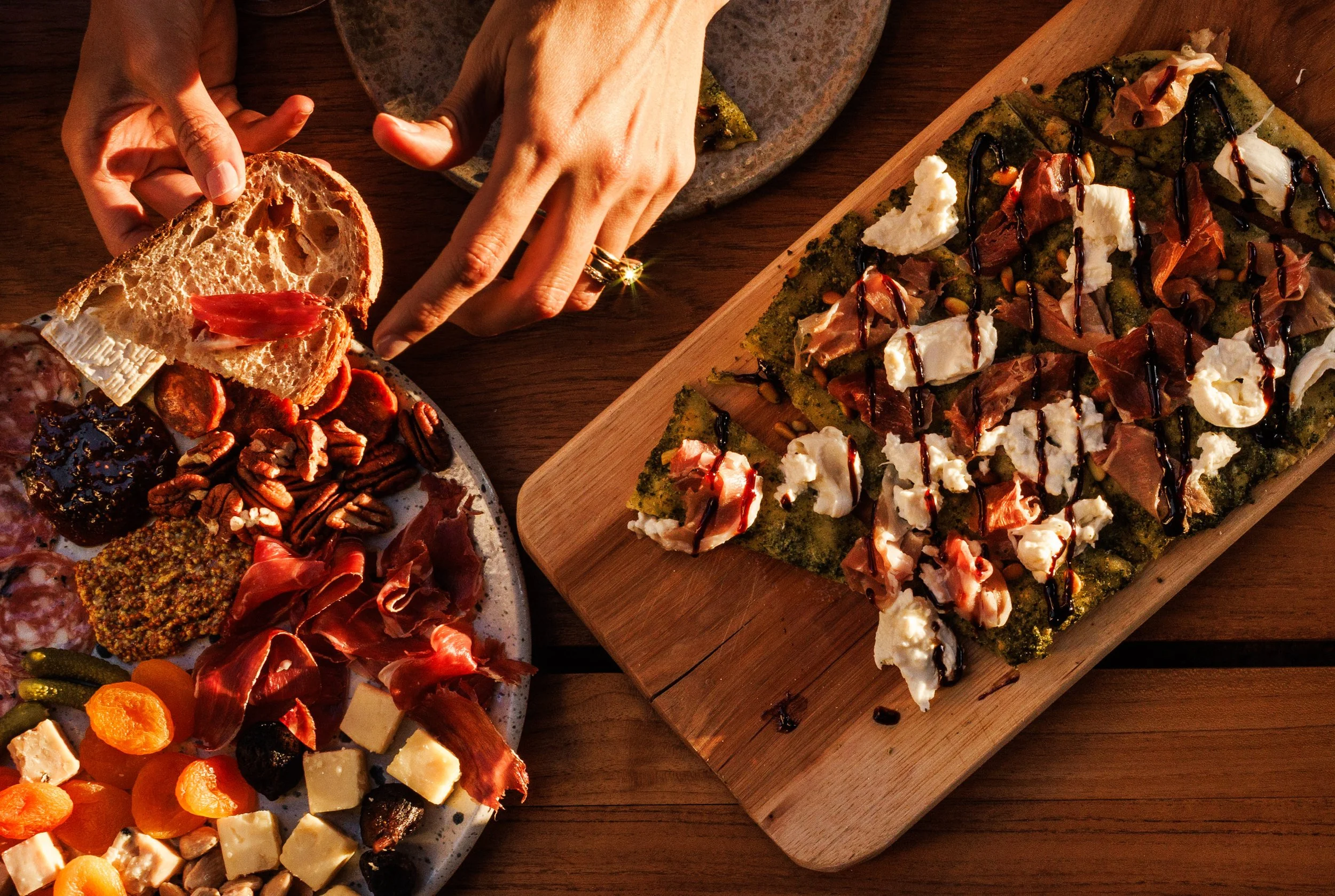 Commercial food lifestyle image of a hand selecting charcuterie from a board.