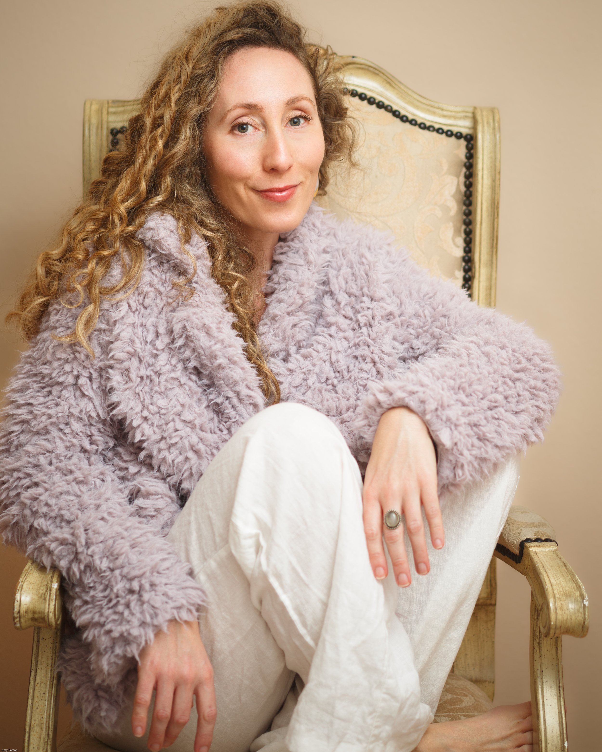 Self portrait of Amy Carson, in soft glowing light, wearing a playful lavender coat. Amy Carson in a San Diego based commercial photographer based specializing in food and drink, lifestyle, and hospitality.