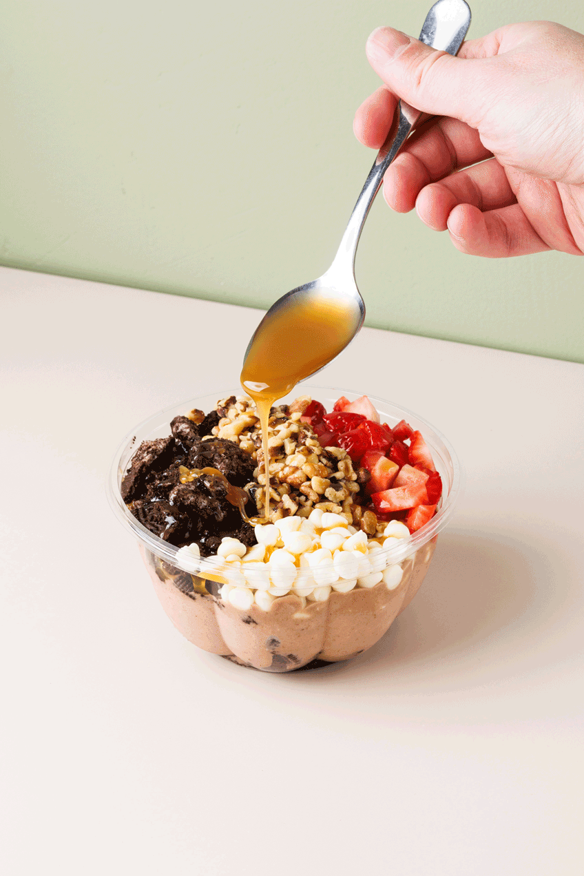 Commercial stop-motion GIF of a hand dripping caramel on a dessert bowl on a clean minimalist background. Shot by San Diego based food and lifestyle product photographer.