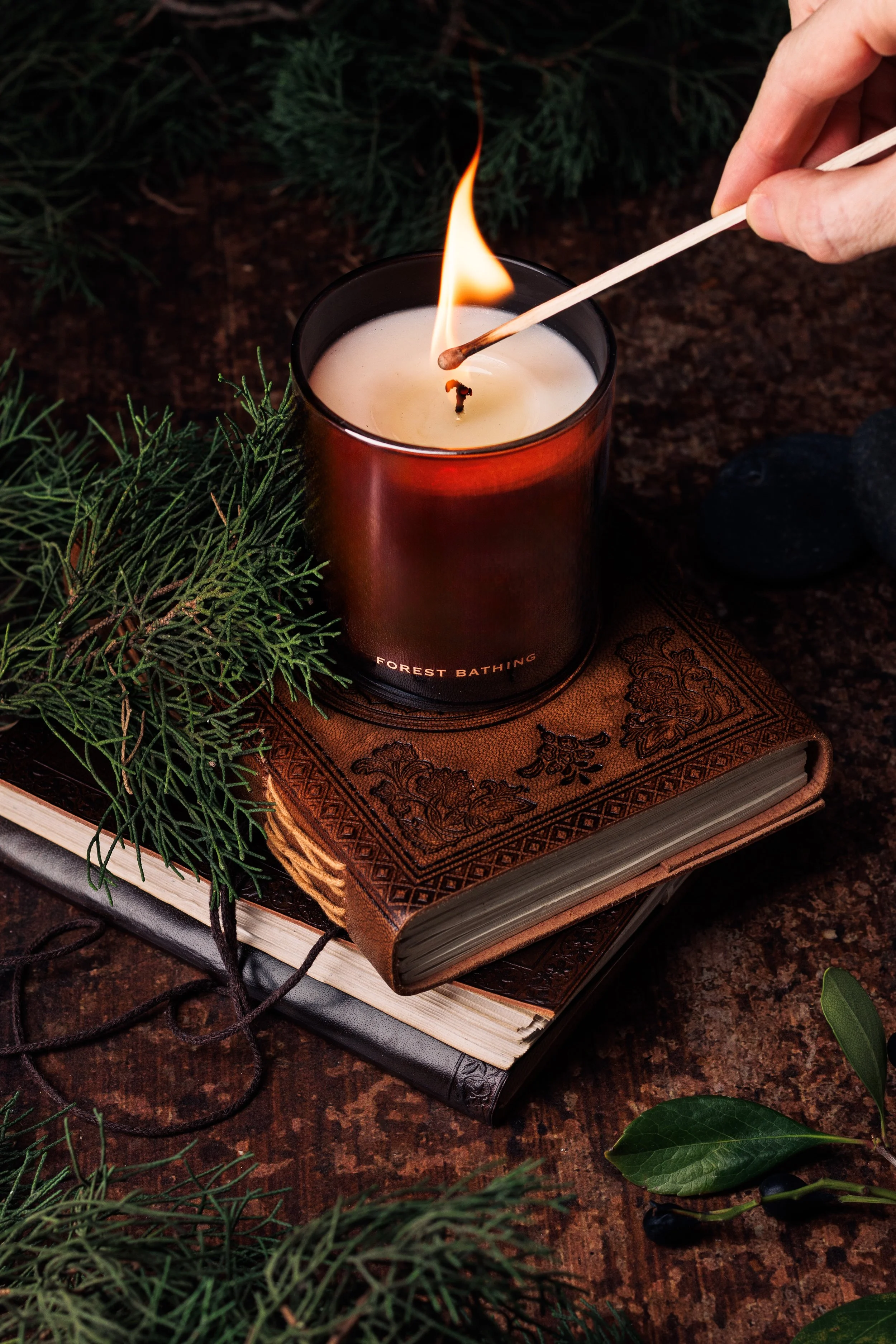 Commercial lifestyle product photo of a candle in a rustic, earthy style.
