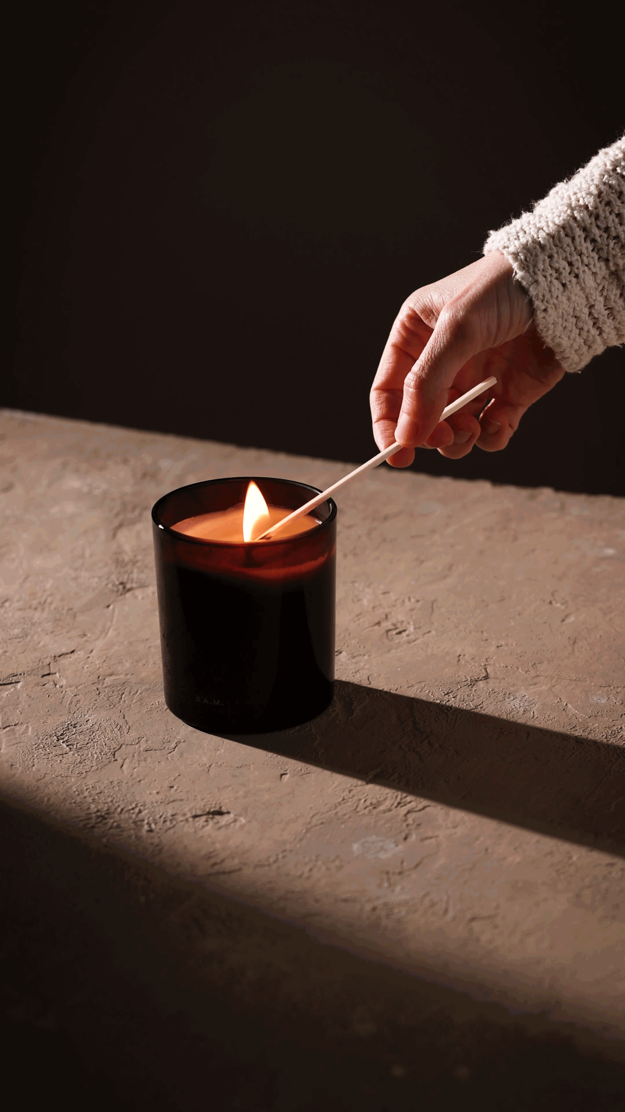 Moody lifestyle product cinemagraph of a candle flicker by San Diego photographer Amy Carson.