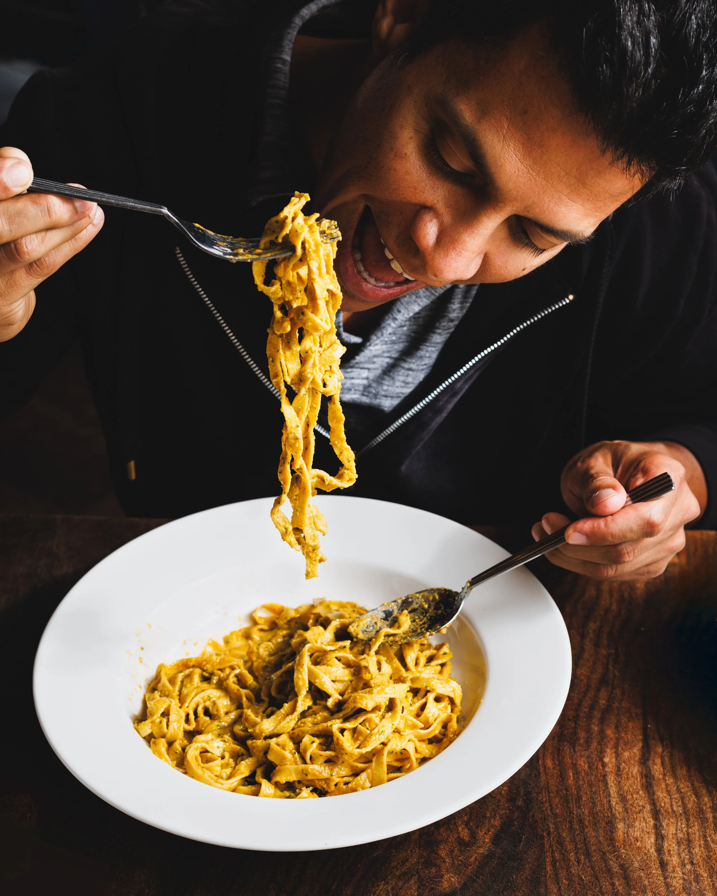Commercial lifestyle photo of a man eating pasta. Shot by San Diego product Amy Carson.