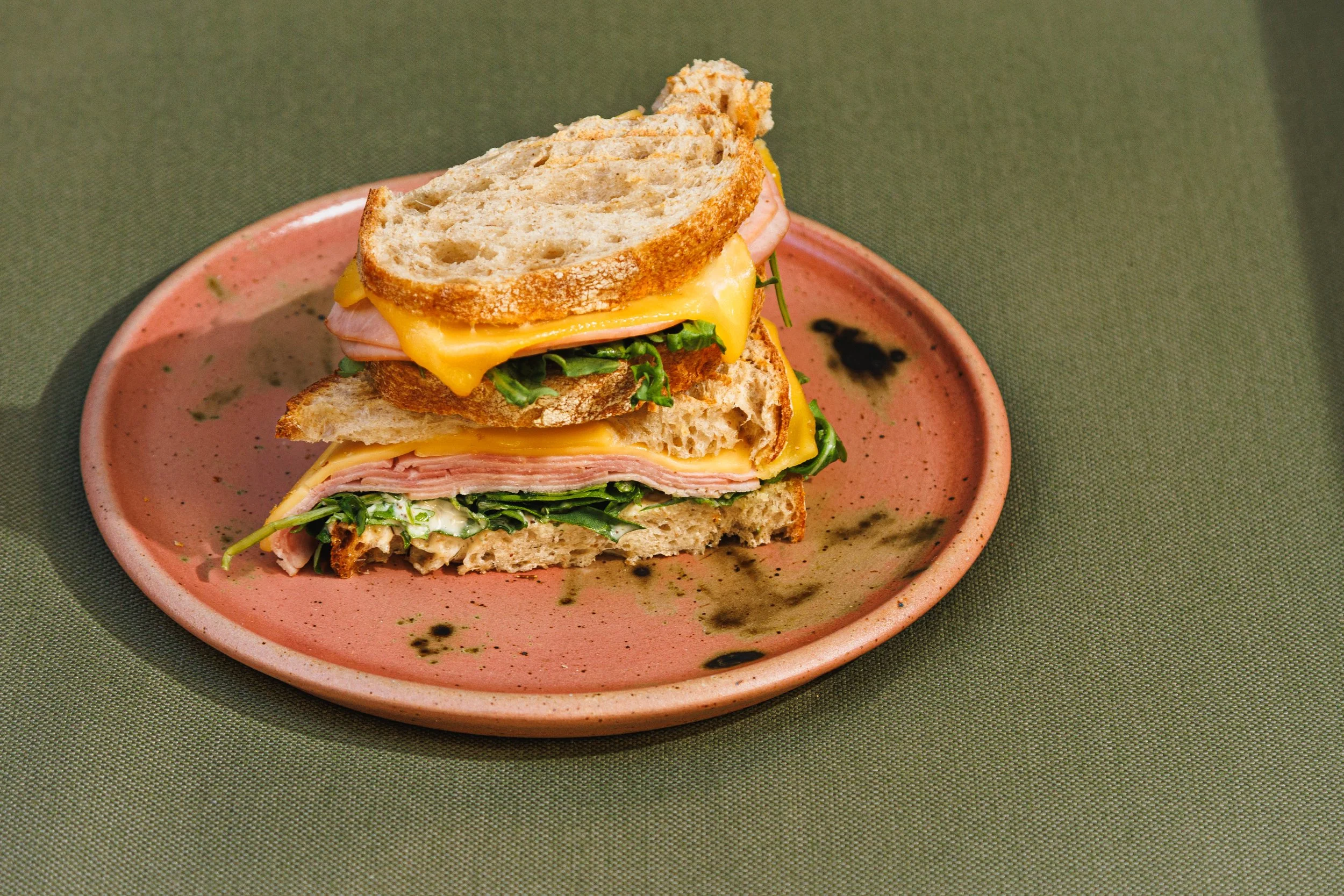 Commercial food photo of a ham and cheese sandwich in hard San Diego sunlight.