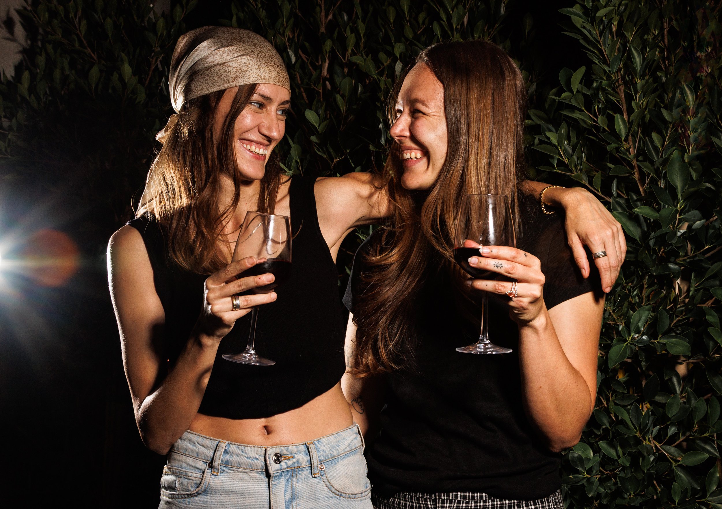 Commercial lifestyle photo of friends embracing with wine glasses in San Diego.