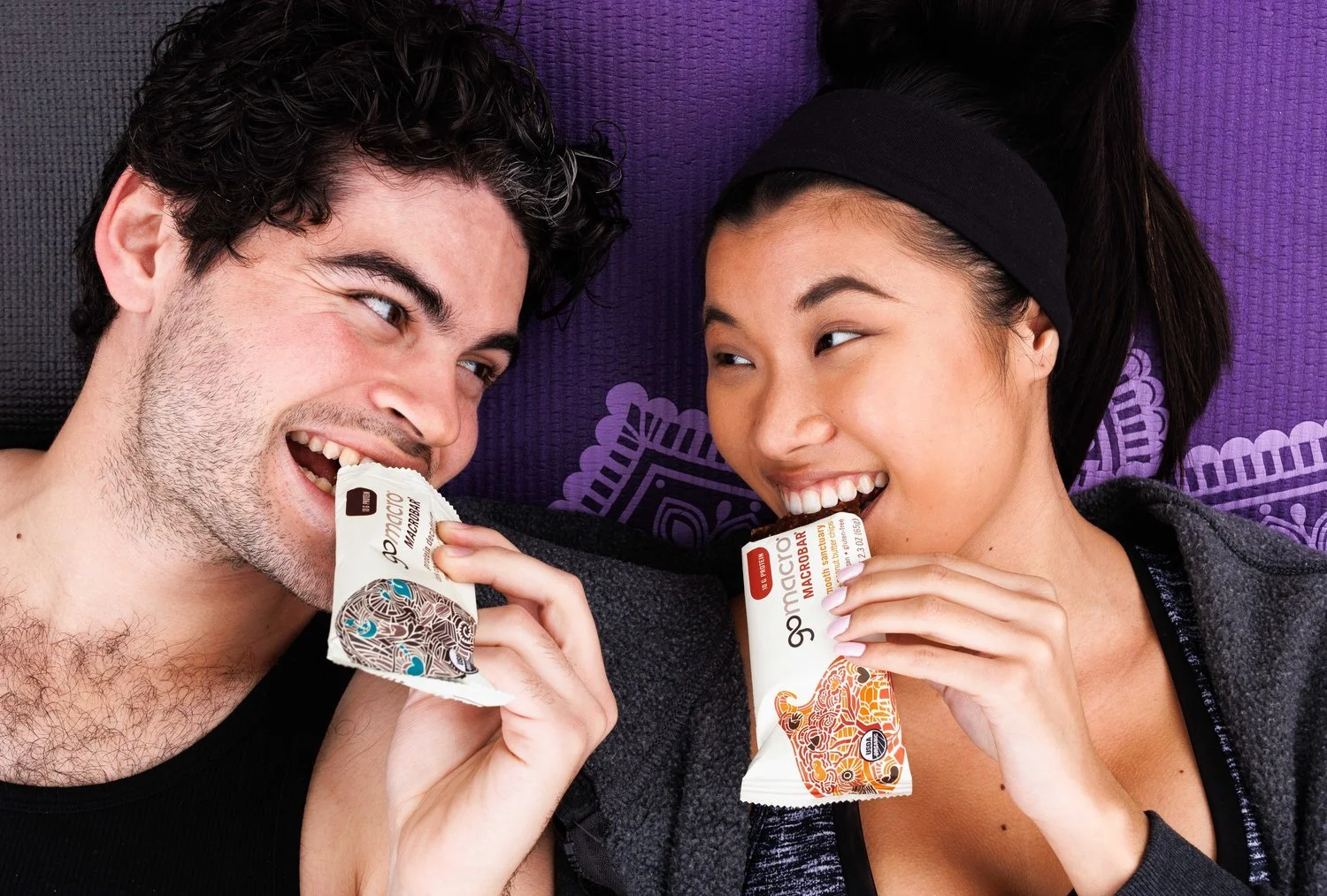 Commercial lifestyle product portraits of couple on yoga mats earing protein bars. Shot by Orange County food photographer Amy Carson.
