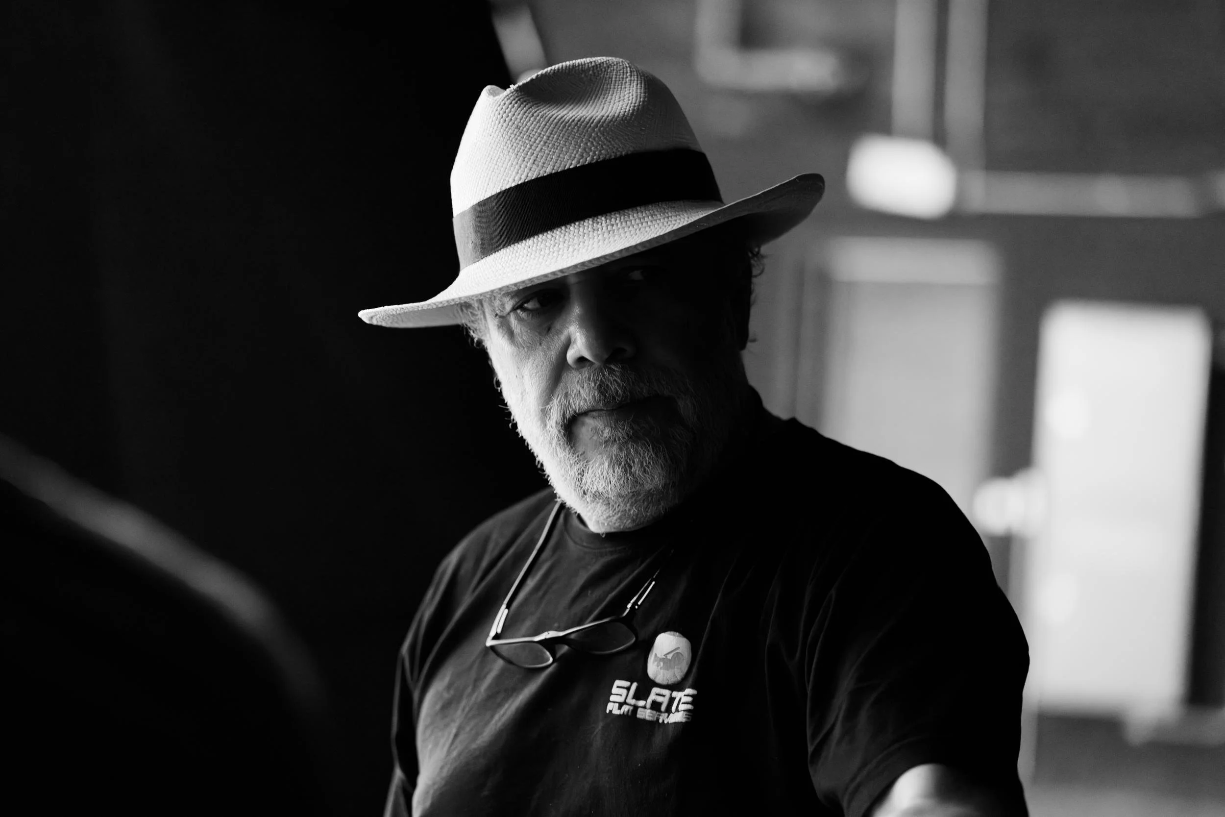 Ahlan Simsim unit still: A black-and-white portrait of a crew member wearing a fedora on a production set.