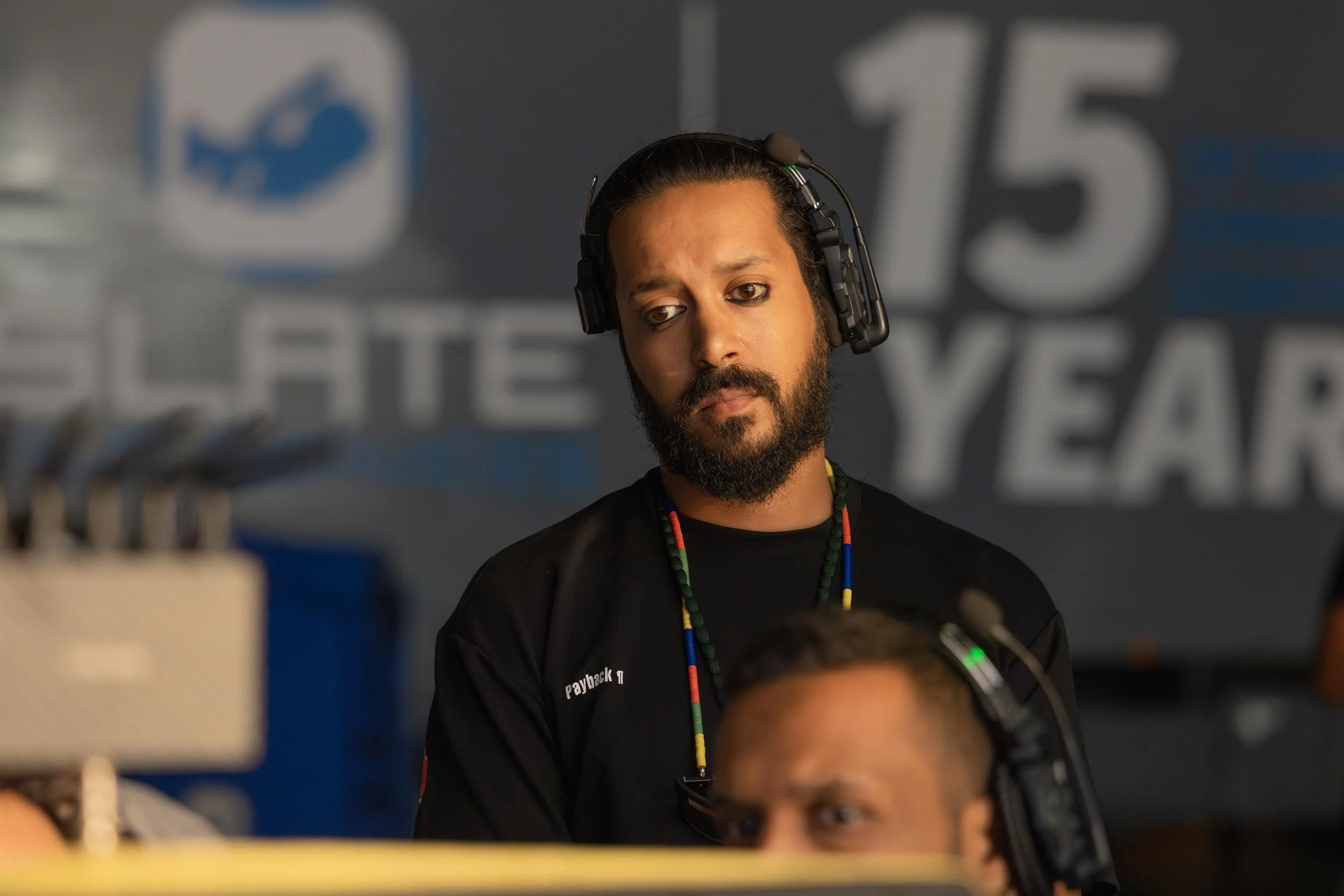 Ahlan Simsim unit still: a crew member wearing a headset looks down thoughtfully on set.