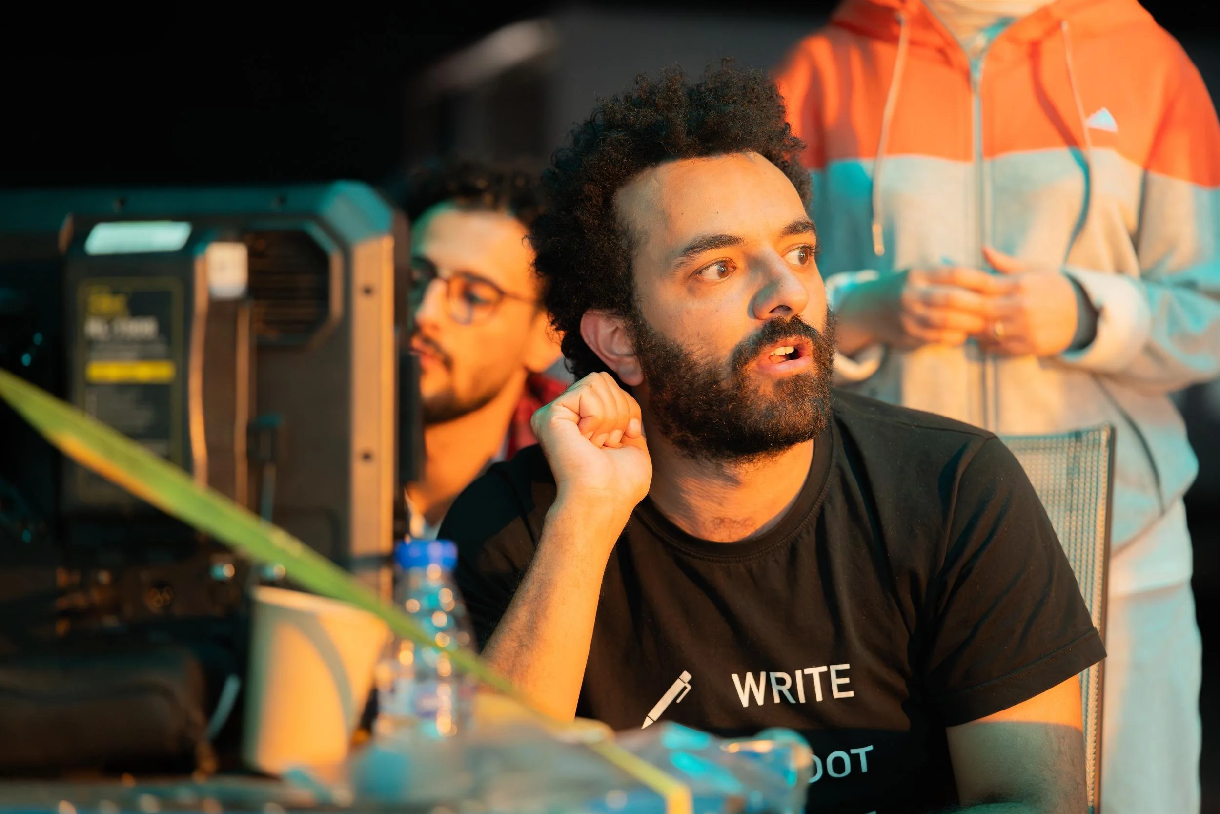 Ahlan Simsim unit still: a crew member in a black t-shirt watches a monitor on set.