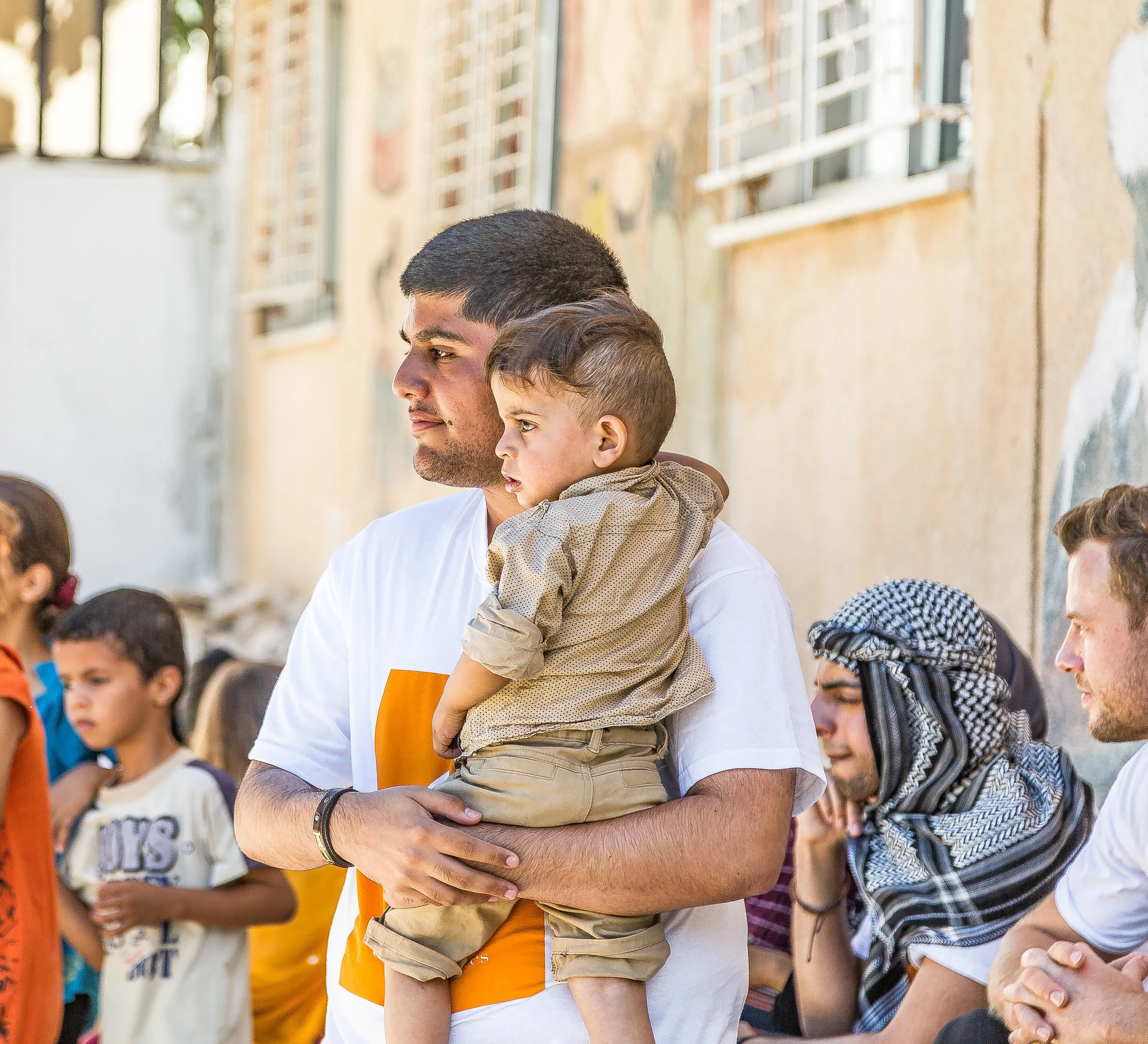 A Photograph by photojournalist Rashad Anabtawi image of a student holding a toddler
