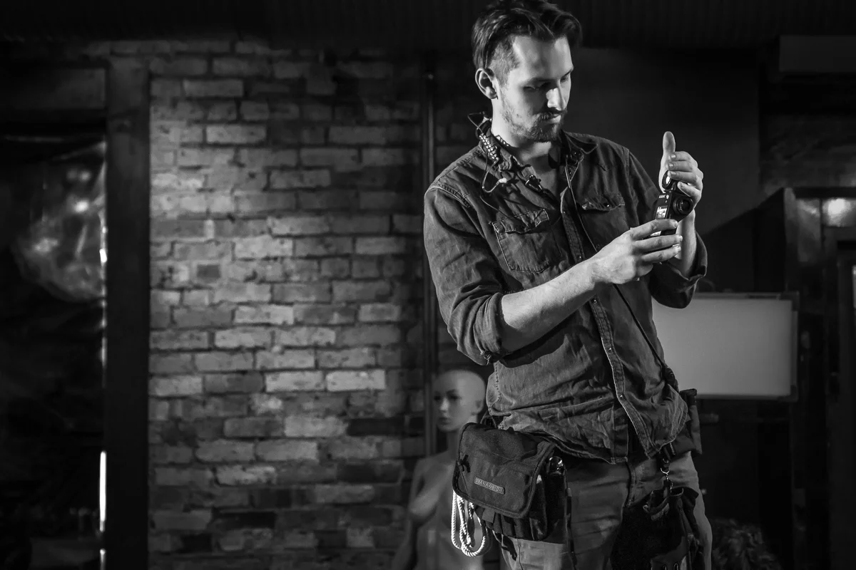 A black and white set Photograph by Chicago Set Photographer Rashad Anabtawi of the Gaffer using his light meter to check the xposure of the scene