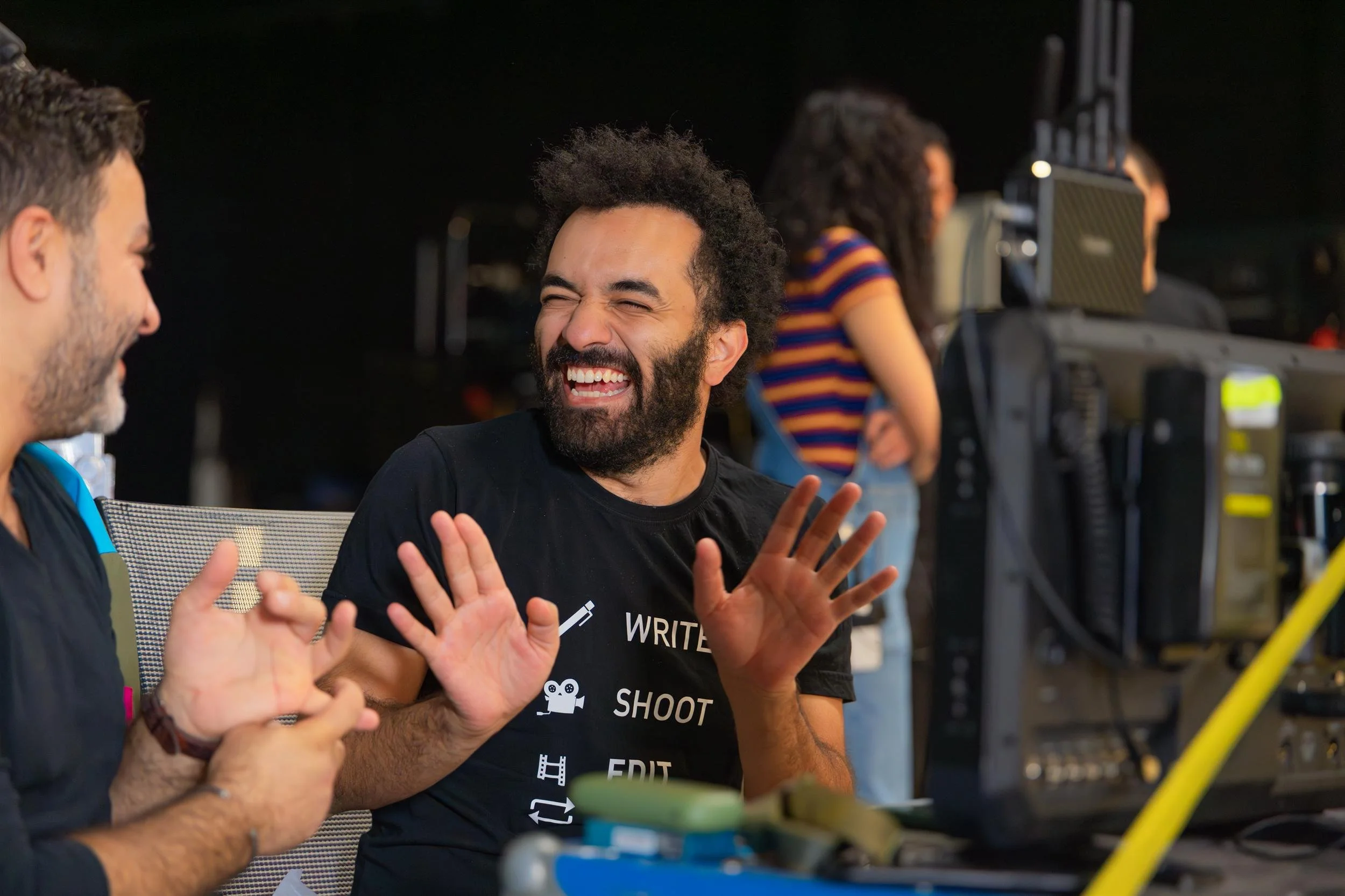 Ahlan Simsim unit still of crew laughing while reviewing playback on set