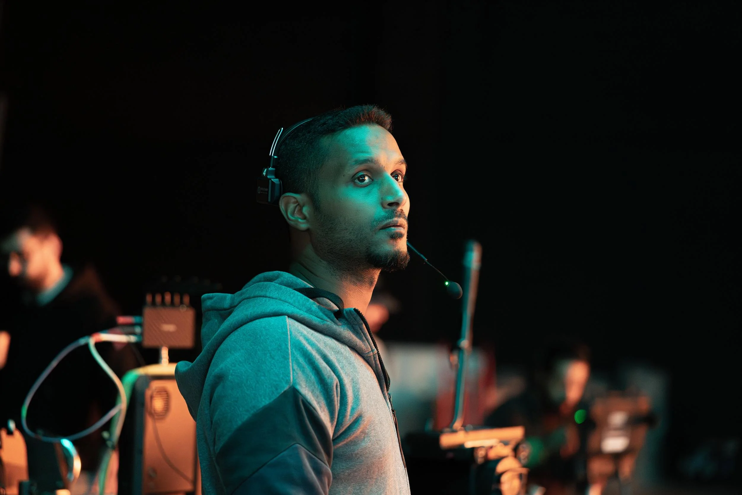 Ahlan Simsim unit still: a crew member in a headset looks up attentively in a dim studio.